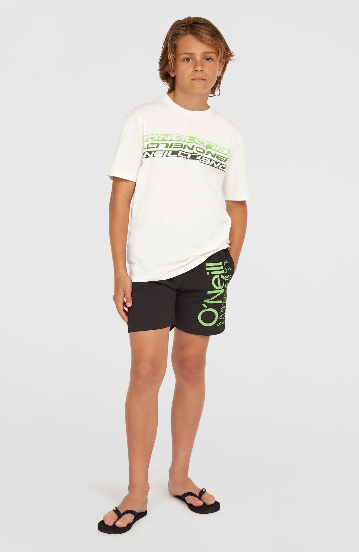 Original Cali 14'' Badehose für Jungen, schwarz mit Logo-Print in Grün, getragen am Model, Ganzansicht