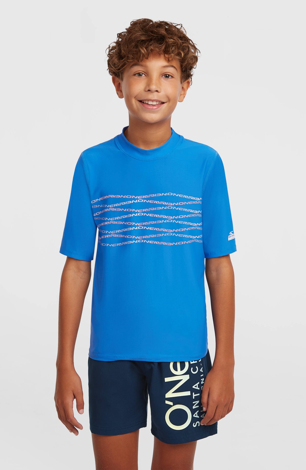 O'Neill Graphic Shortsleeve-UV-Shirt für Jungen, blau mit Logo-Print in Rosa, Vorderansicht am Model