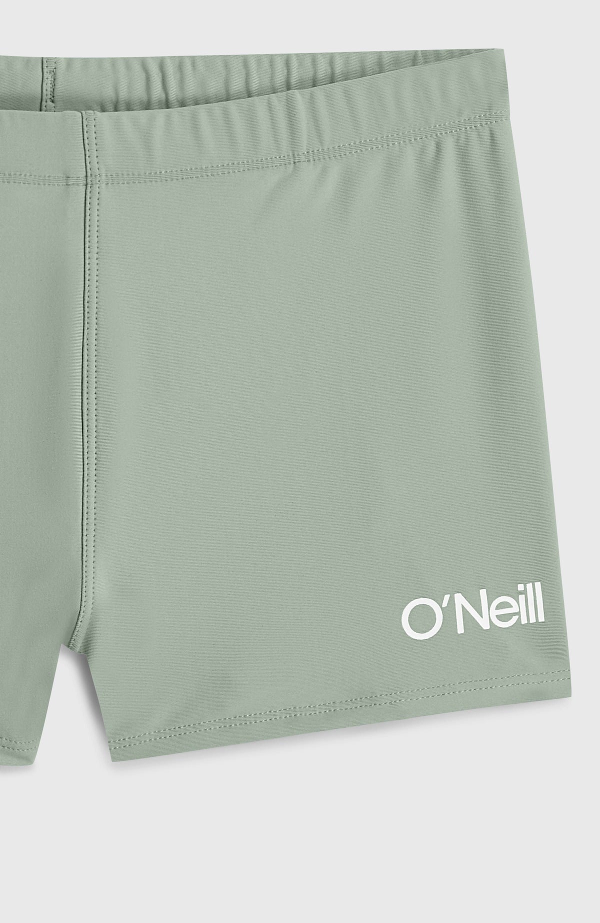 Nahaufnahme der grünen Racer Badehose für Jungen mit weißem Logo-Print am Saum