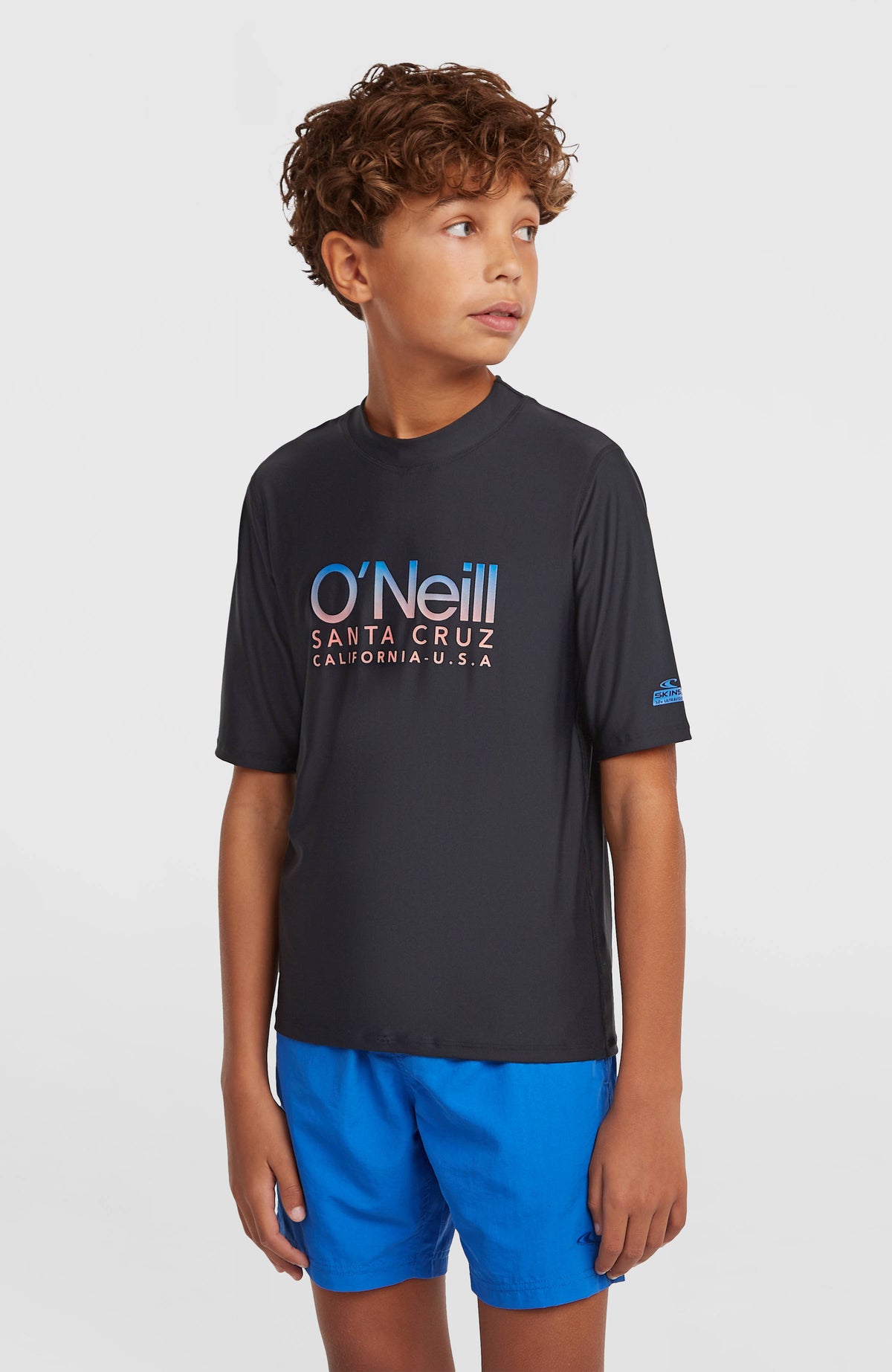 O'Neill Shortsleeve-UV-Shirt für Jungen, schwarz mit Logo-Print in Blau und Rosa, Vorderansicht am Model