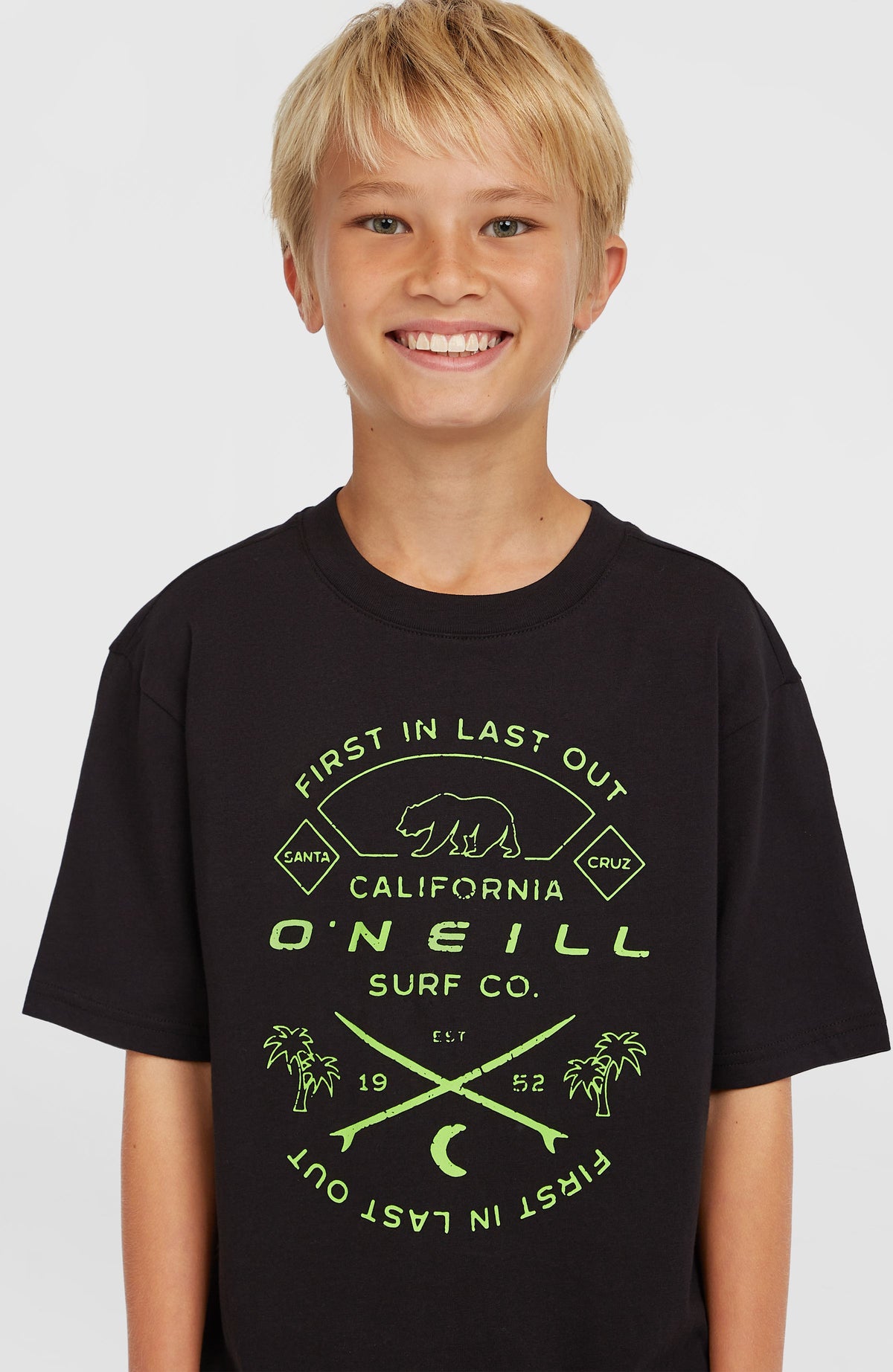 Jack O'Neill Muir T-Shirt für Jungen, schwarz mit Grafik-Print in Grün, Nahaufnahme des Brust-Prints am Model