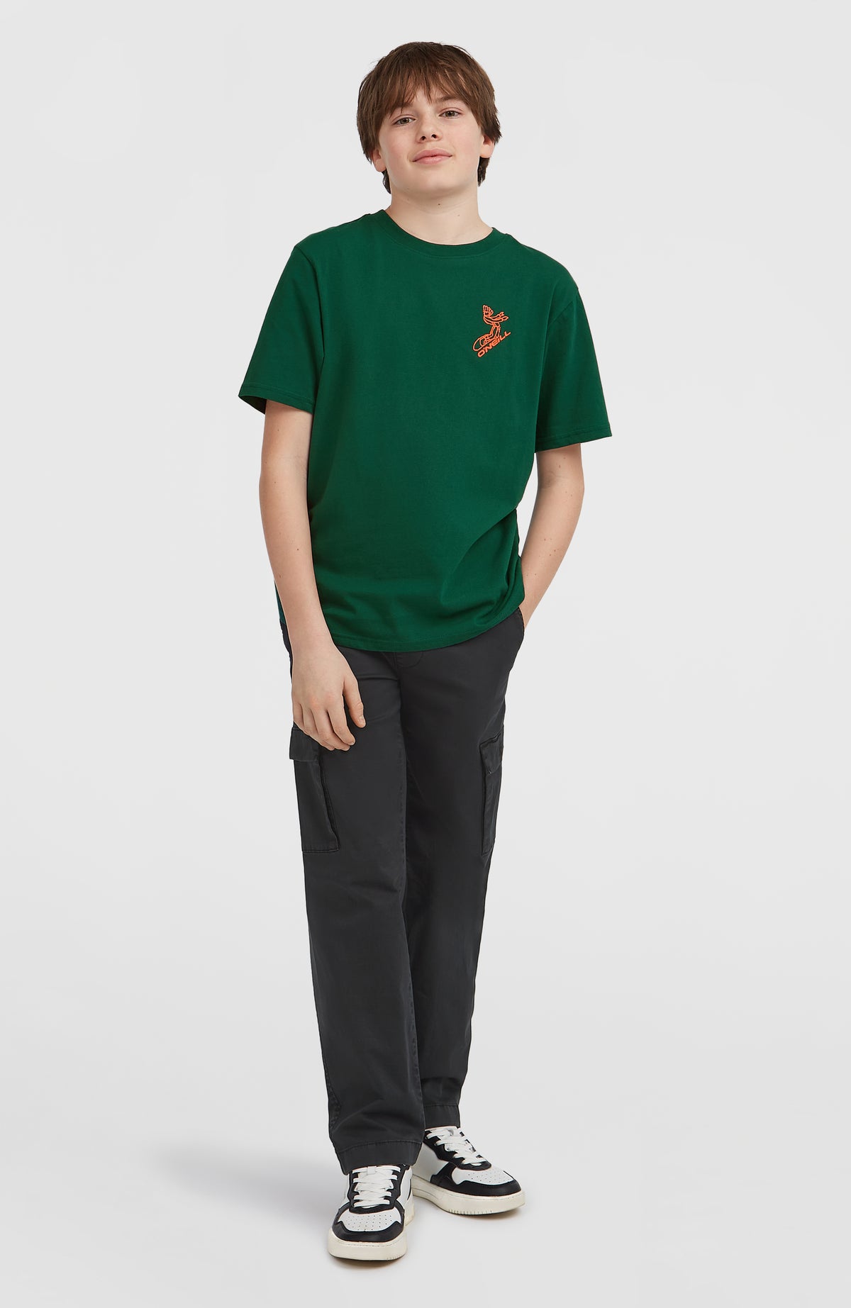Grünes Back-Print T-Shirt für Jungen mit Grafik-Print in Orange, getragen am Model in Ganzkörperansicht