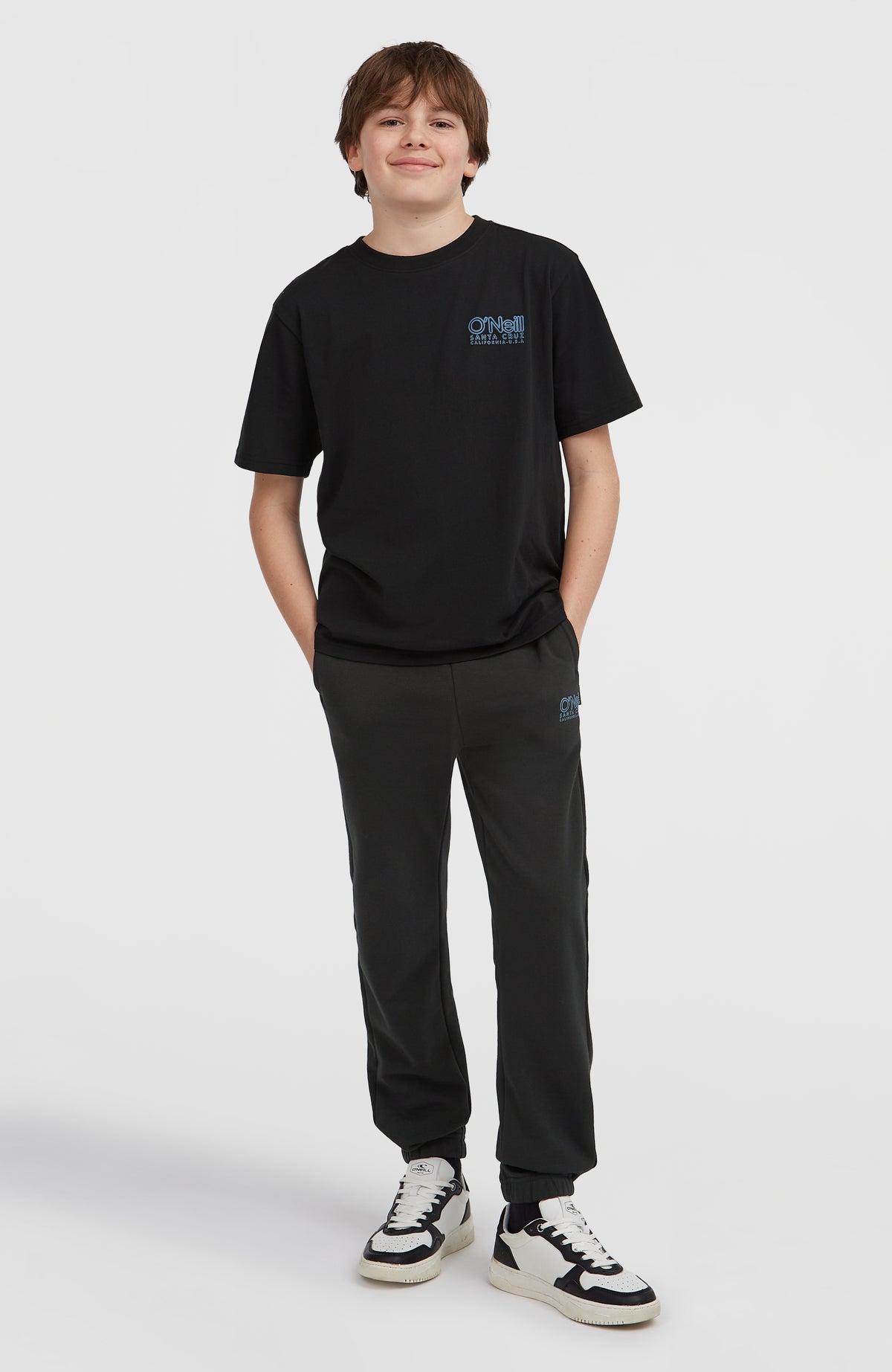 Essentials Cali Logo T-Shirt für Jungen, schwarz mit Logo-Print in Blau, getragen am Model, Ganzkörperansicht von vorne