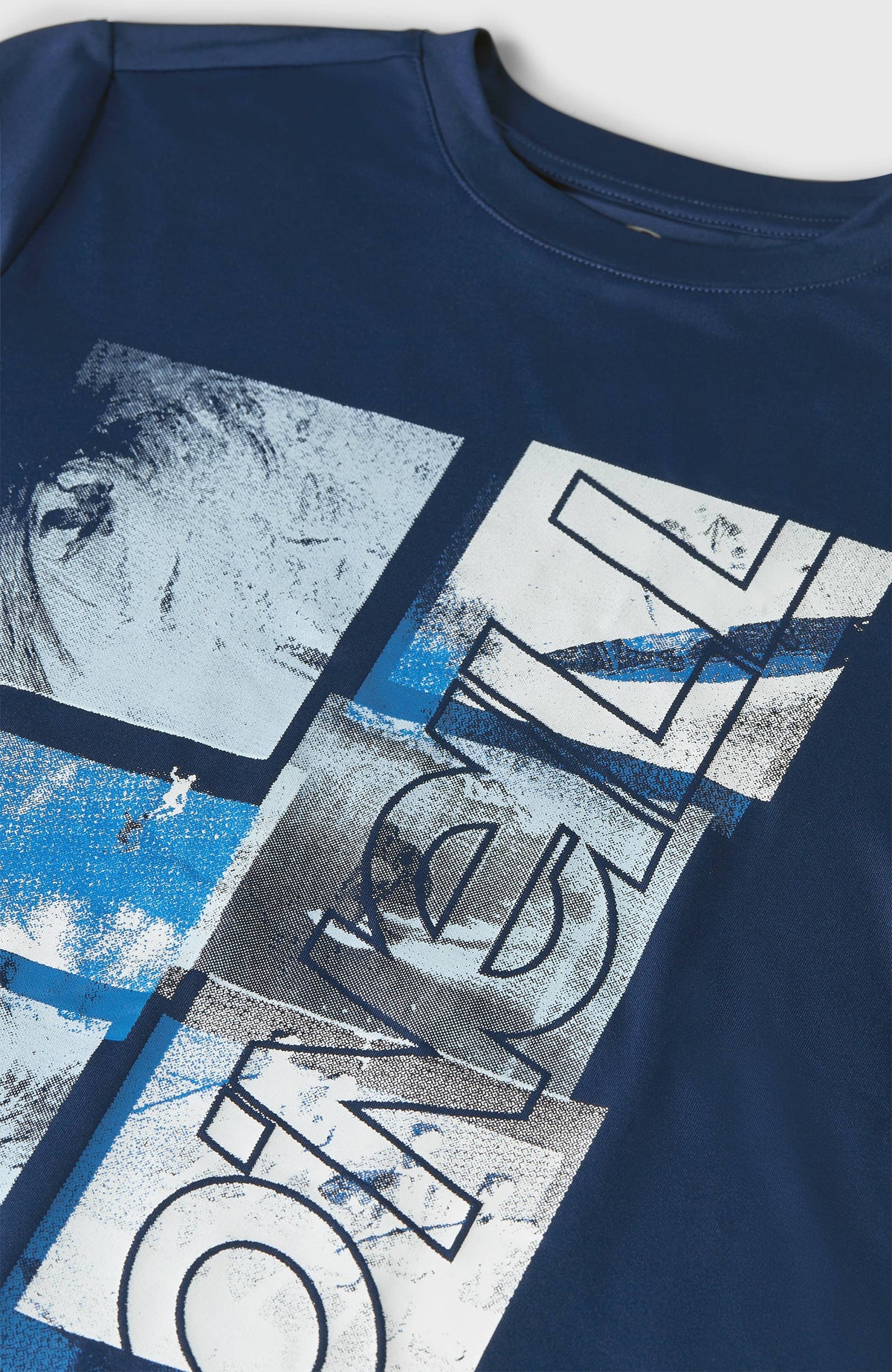 Nahaufnahme vom Logo-Print in Weiß und Hellblau auf dem blauen Hybrid T-Shirt für Jungen, flach liegend