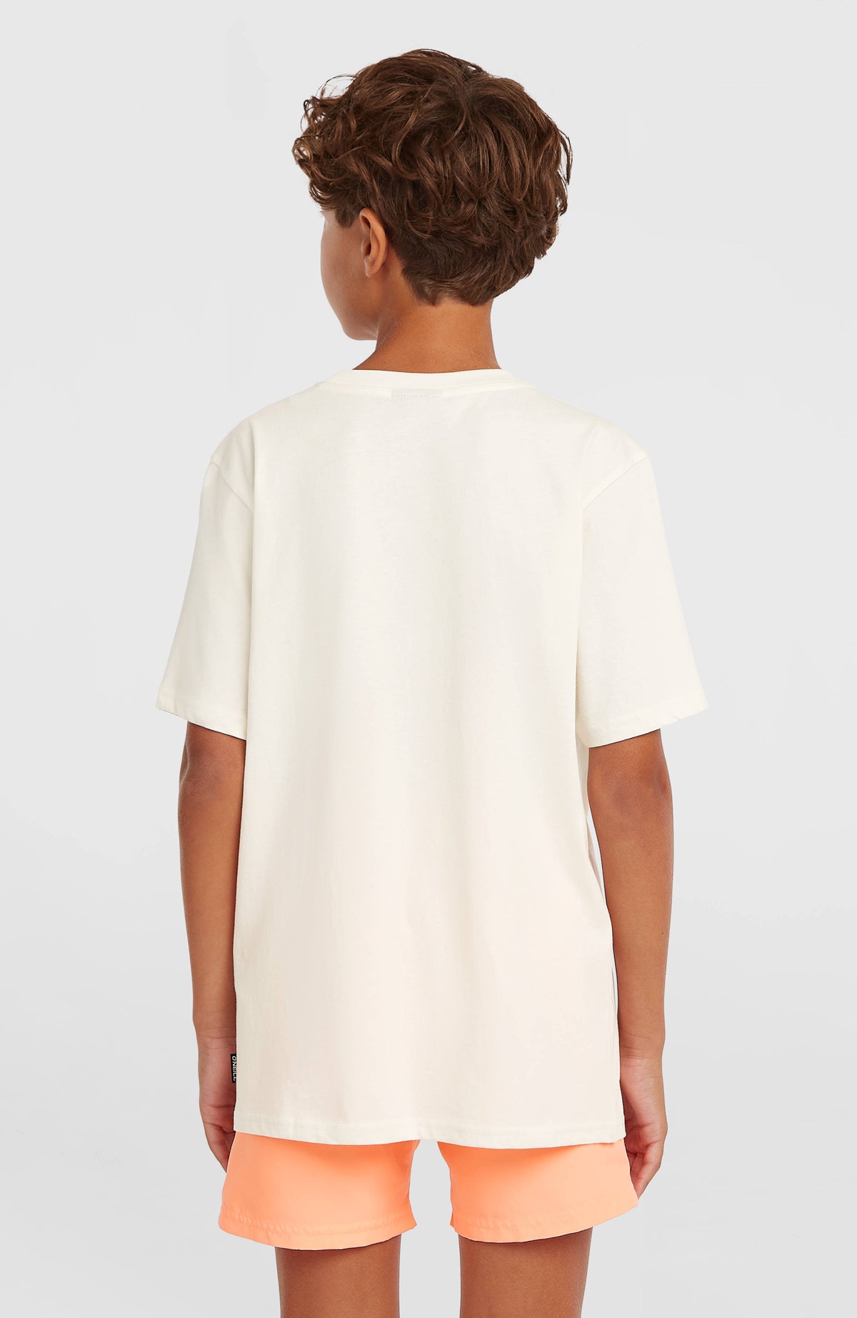 Muir T-Shirt für Jungen, weiß, Rückansicht am Model mit kleinem Webetikett am Saum