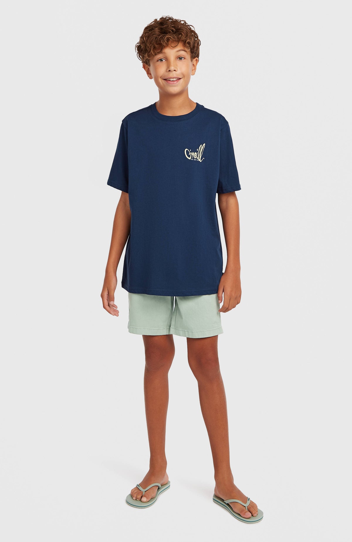 Chest-Print T-Shirt für Jungen, blau mit Logo-Print in Cremeweiß, frontale Ganzkörperansicht, am Model