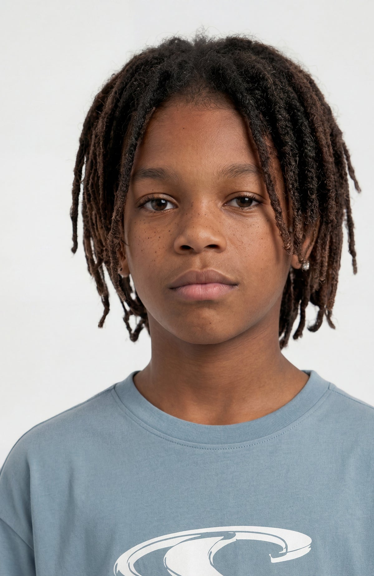 Essentials T-Shirt für Jungen, blau mit Logo-Print in Weiß, Nahaufnahme des Rundhalsausschnitts am Model