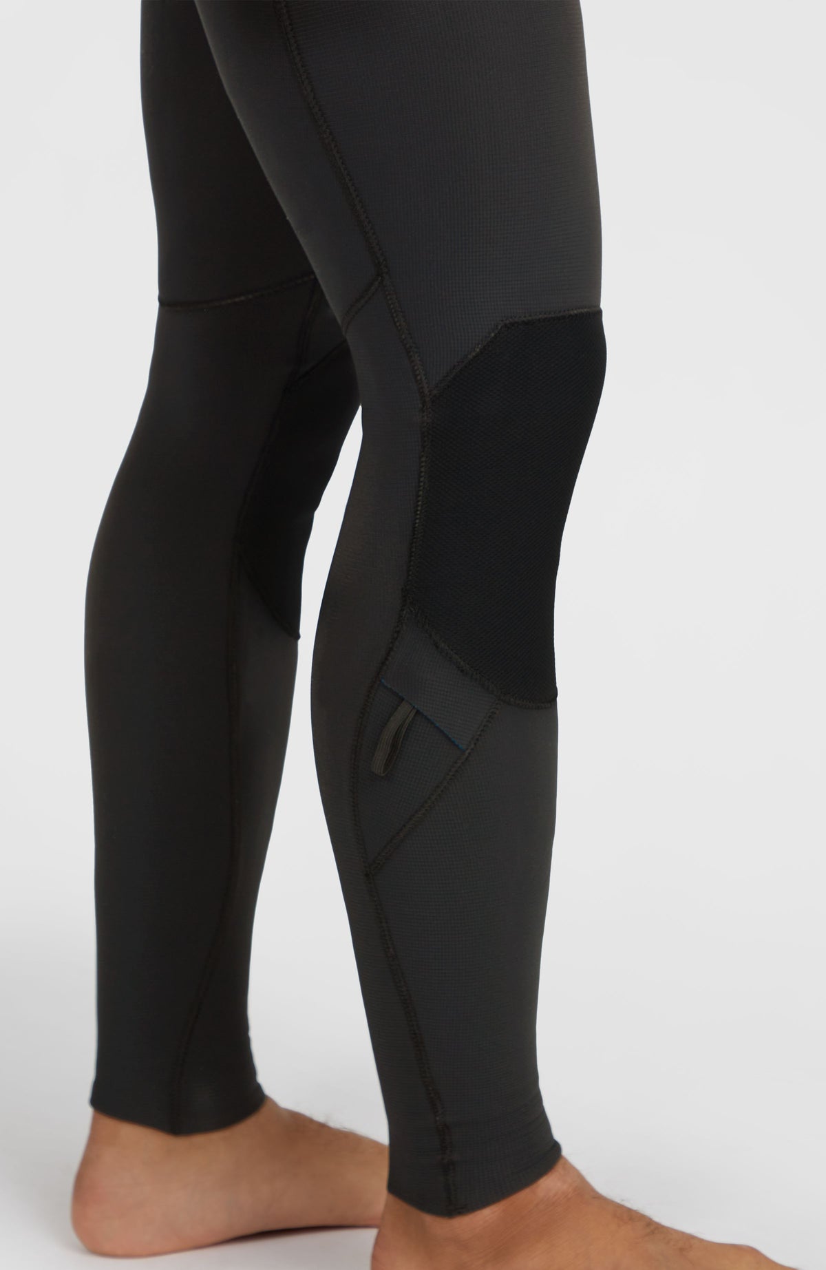 Hyperfreak 3/2mm Neoprenanzug für Herren, schwarz, Nahaufnahme der Verstärkung und Tasche am Hosenbein am Model