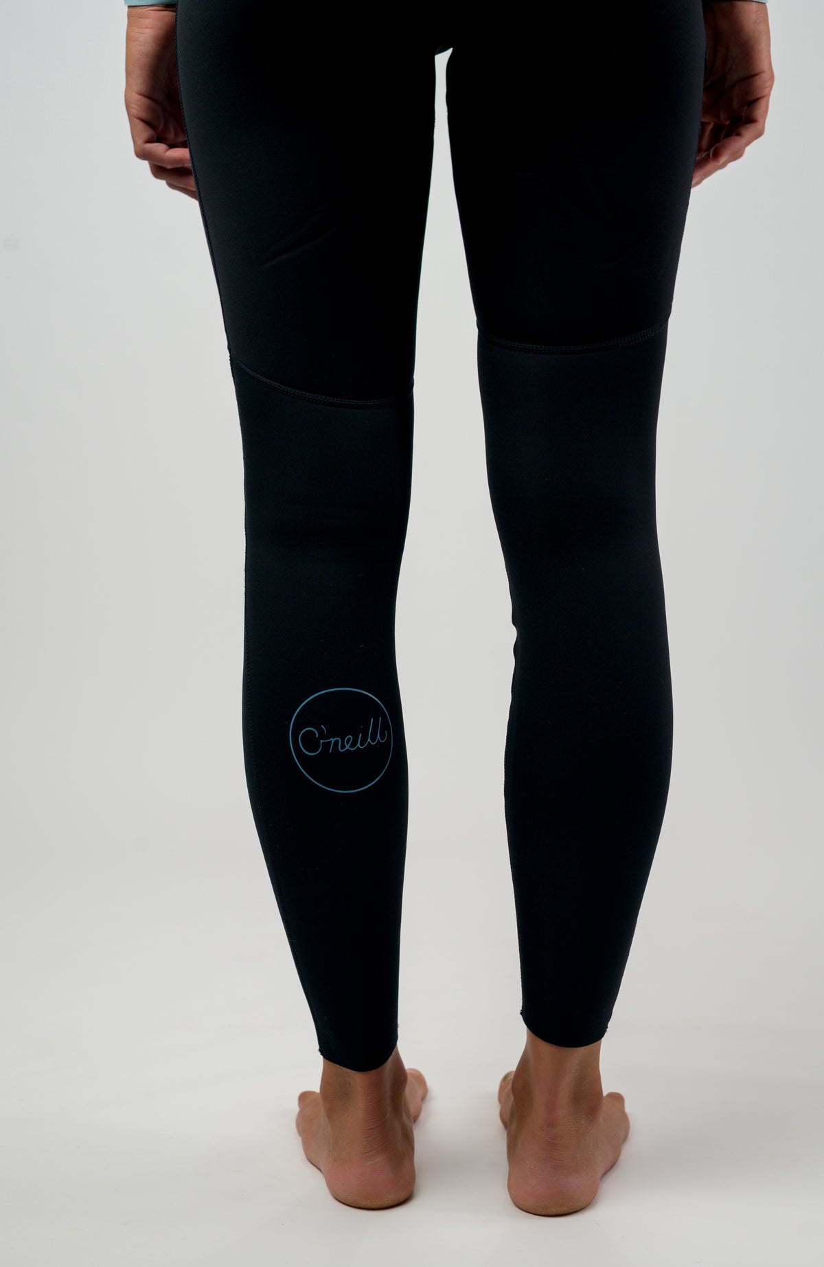 Schwarzer Wms Bahia 3/2 Back Zip Full Neoprenanzug für Damen, am Model von hinten, runder Logo-Print am Hosenbein