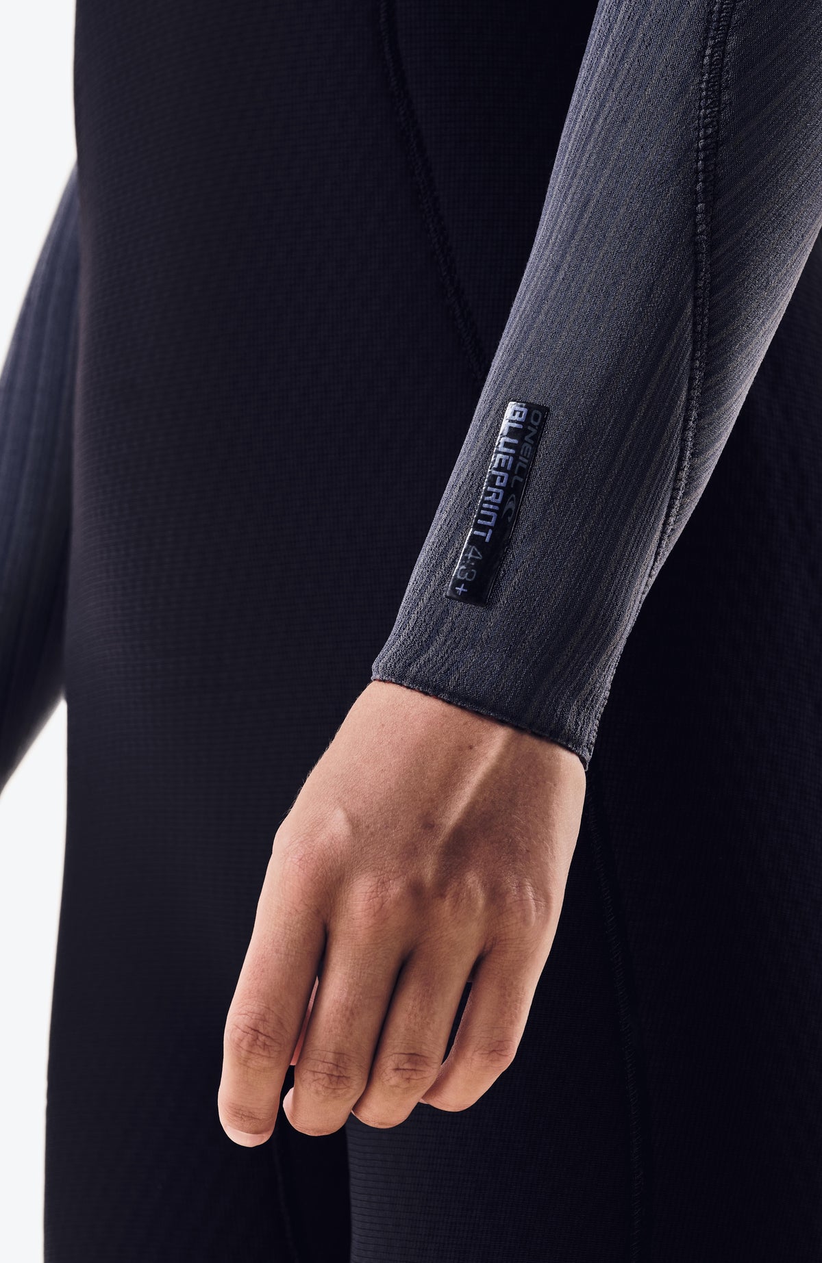 Blueprint 5/4mm Chest Zip Full Wetsuit Neoprenanzug, schwarz, Nahaufnahme am Ärmelabschluss mit Label