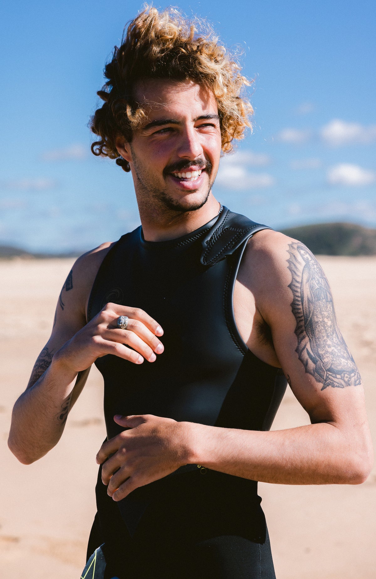 O'Riginals 2mm Long John Wetsuit Neoprenanzug, schwarz, am Strand, Ansicht von schräg vorne mit Klett-Träger