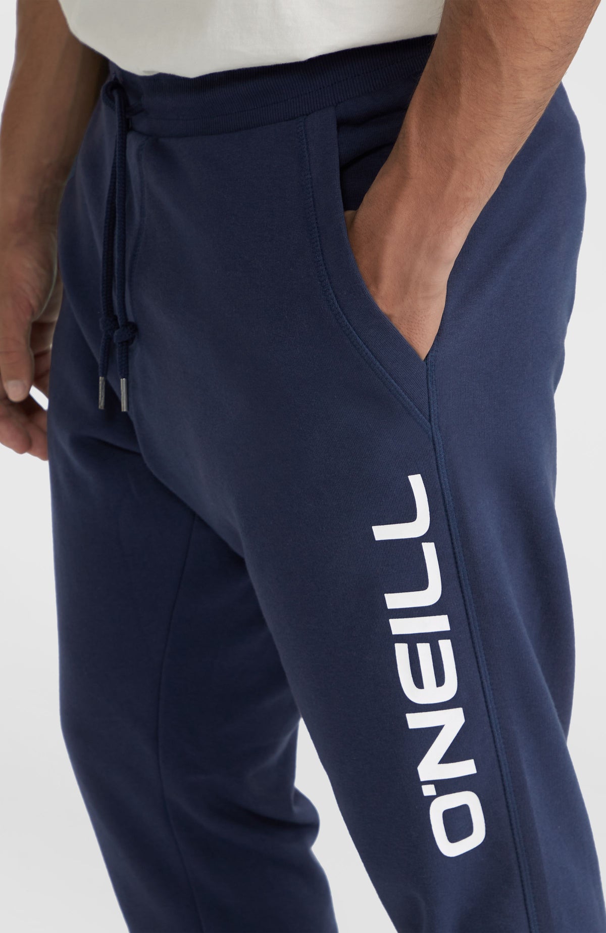Nahaufnahme der blauen Logo Jogginghose mit Eingrifftasche und seitlichem Logo-Print in Weiß