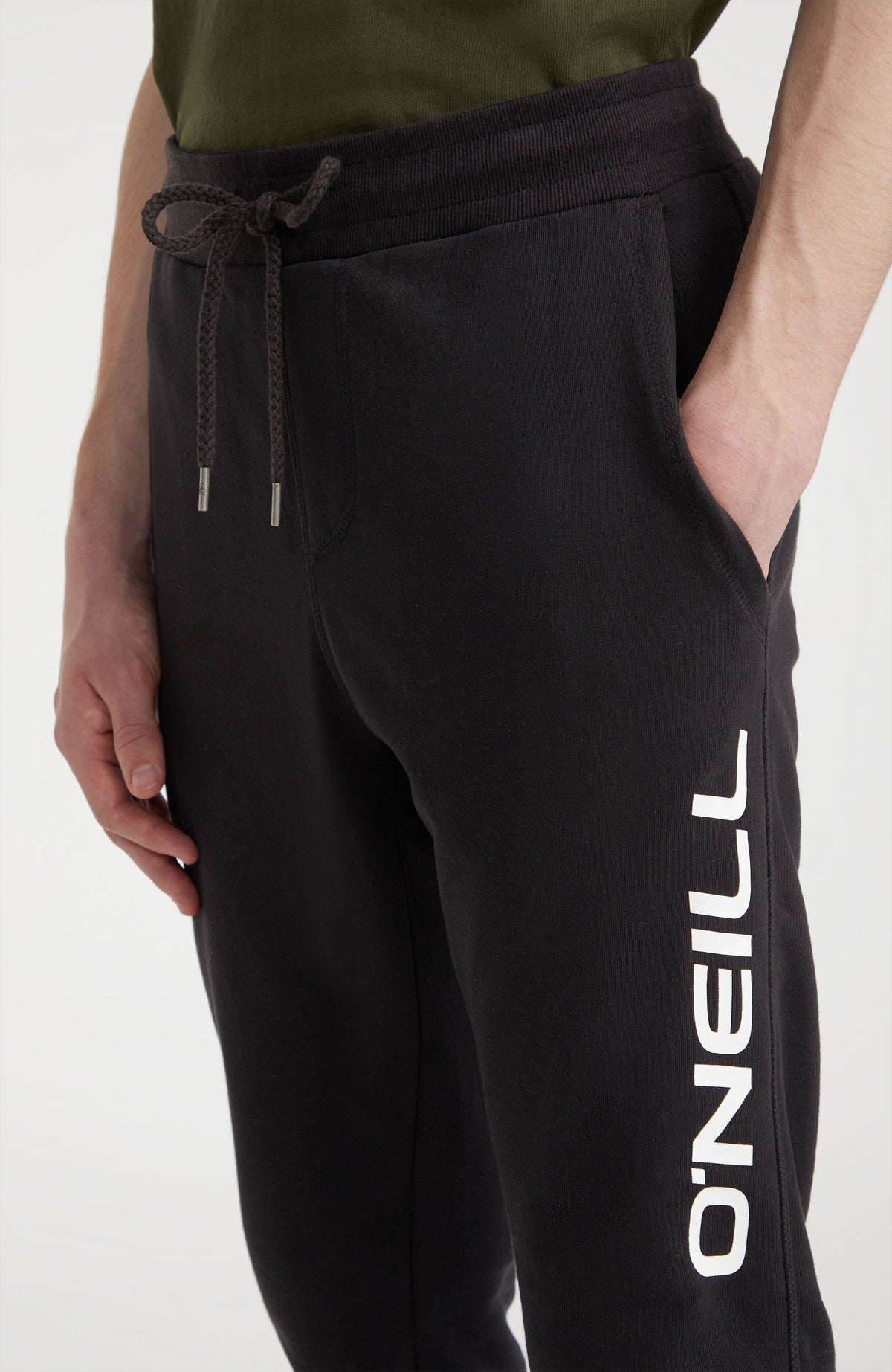 Nahaufnahme der schwarzen Logo Jogginghose mit Logo-Print in Weiß am Model, elastischer Bund mit Kordelzug