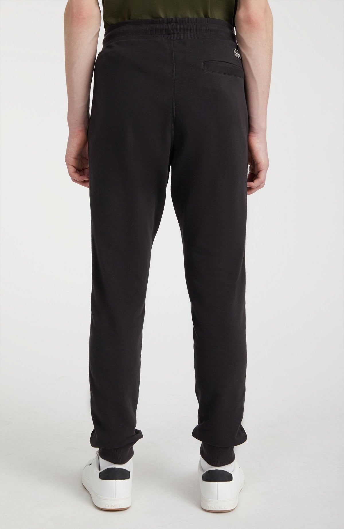 Logo Jogginghose für Herren, schwarz mit Logo-Print in Weiß, Rückansicht am Model mit Gesäßtasche und Patch