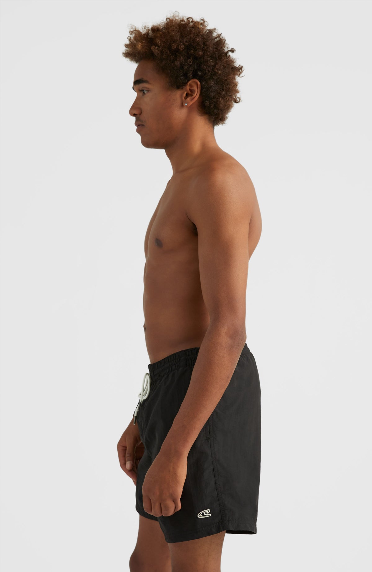 Vert 16'' Badehose für Herren, schwarz, Seitenansicht getragen am Model mit weißem Logo-Print am Hosenbein