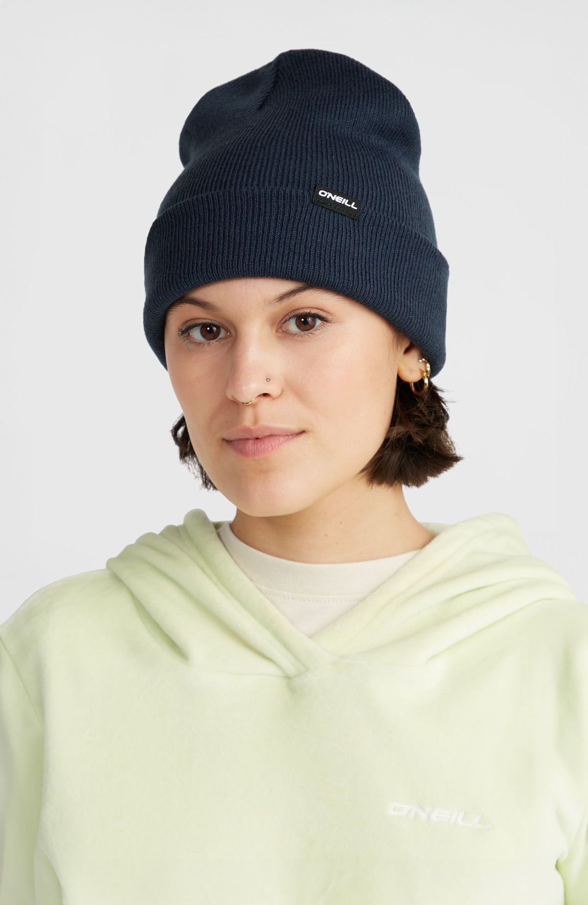Dolomite Beanie, blau, getragen am Model mit umgeschlagenem Saum und Logo-Patch