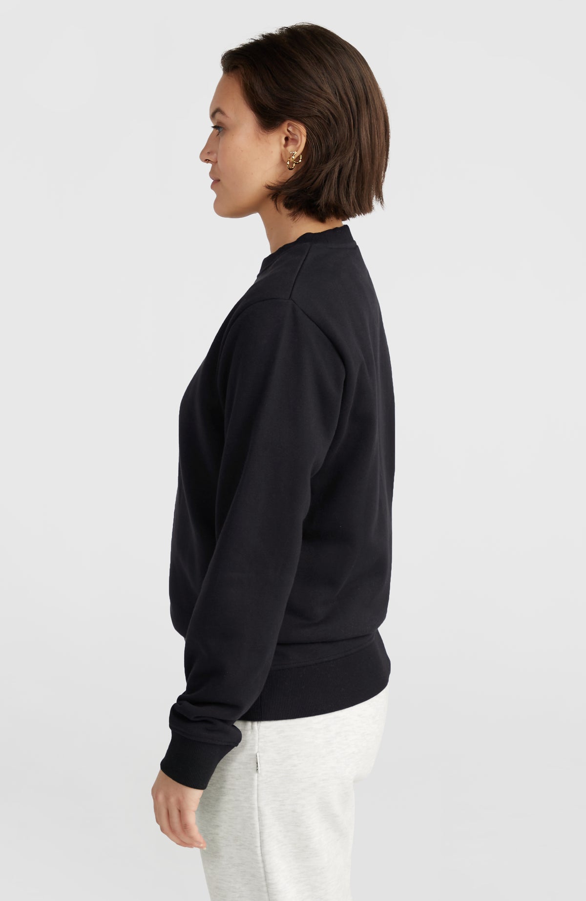 Women of the Wave Crew Sweatshirt für Damen, schwarz, Seitenansicht am Model mit Fokus auf Ärmelbündchen und Saum