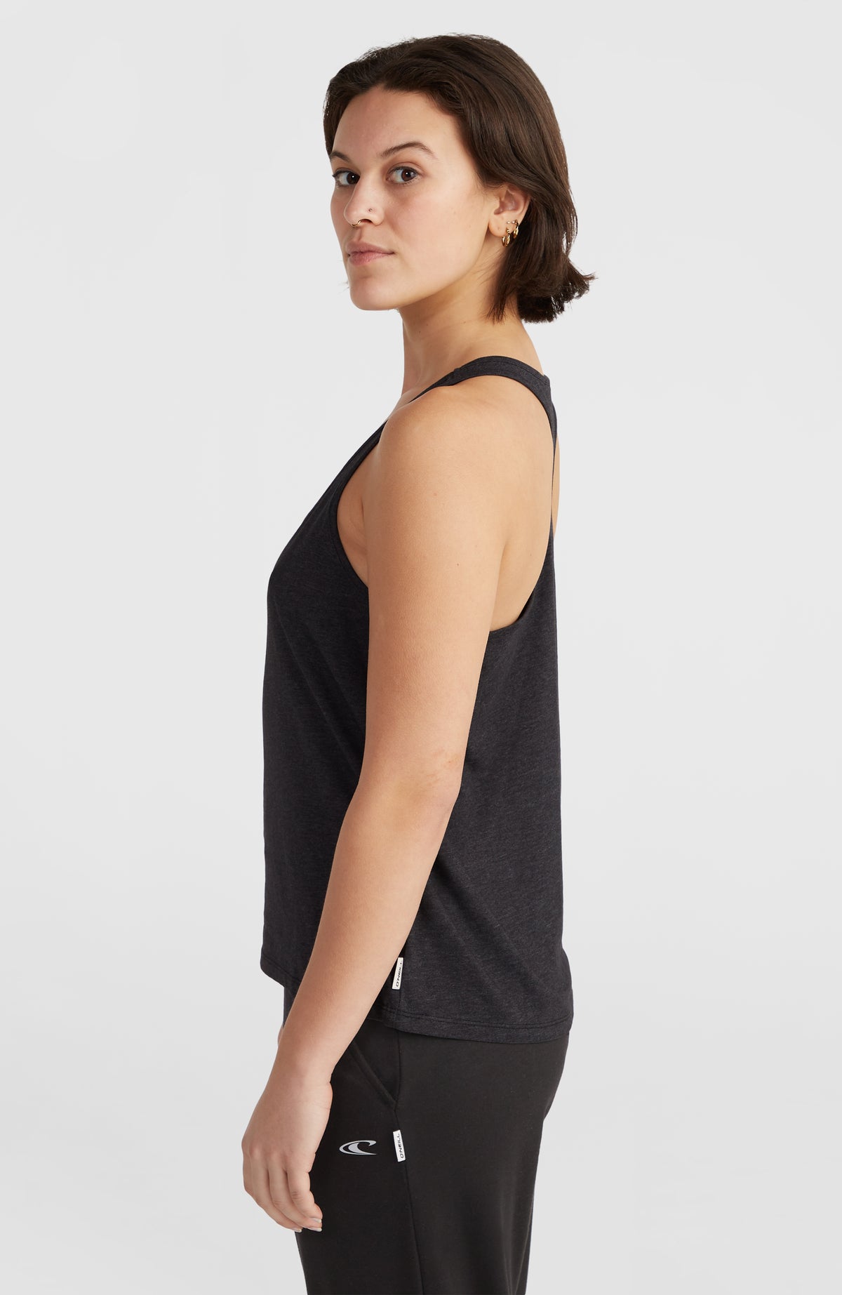 Essentials Racerback-Tanktop für Damen, schwarz, Seitenansicht am Model mit Logo-Label am Saum