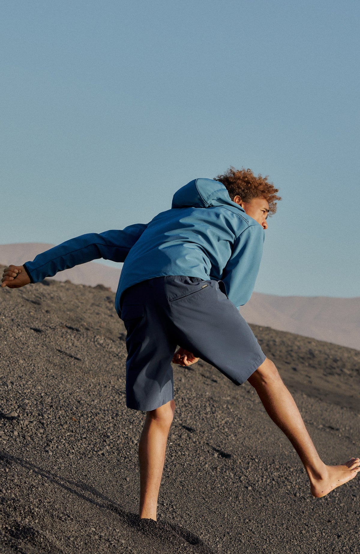 Hybrid Chino-Shorts für Herren, blau, Outdoor-Szene in steiniger Landschaft, getragen am Model