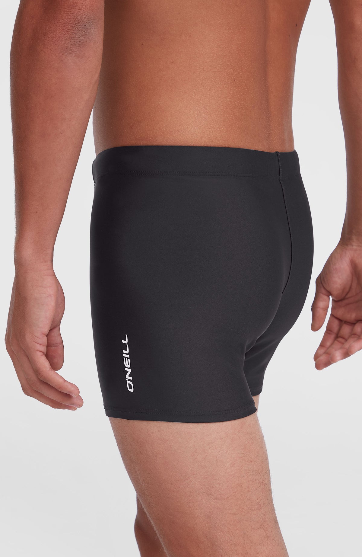 Essentials Racer Badehose für Herren, schwarz, Seitenansicht am Model mit vertikalem Logo-Schriftzug