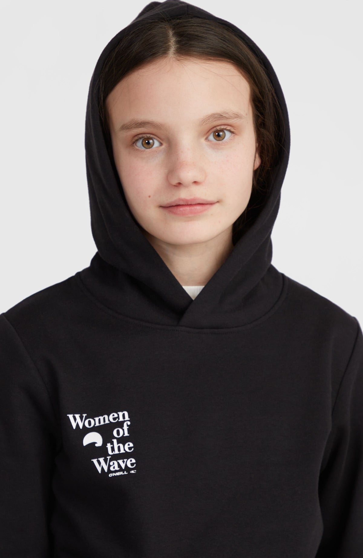 Women of the Wave Hoodie für Mädchen, schwarz, Nahaufnahme am Model mit aufgesetzter Kapuze