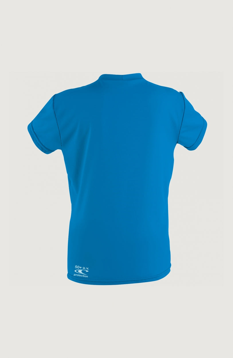 Skins Short Sleeve Rash Tee für Jungen, blaues Schwimmshirt, freigestellt von hinten mit kleinem Print am Saum