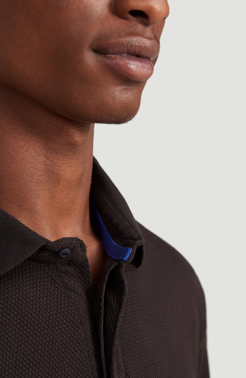 Nahaufnahme von Kragen und Knopfleiste am schwarzen Hybrid Waffle Polo Shirt Poloshirt für Herren