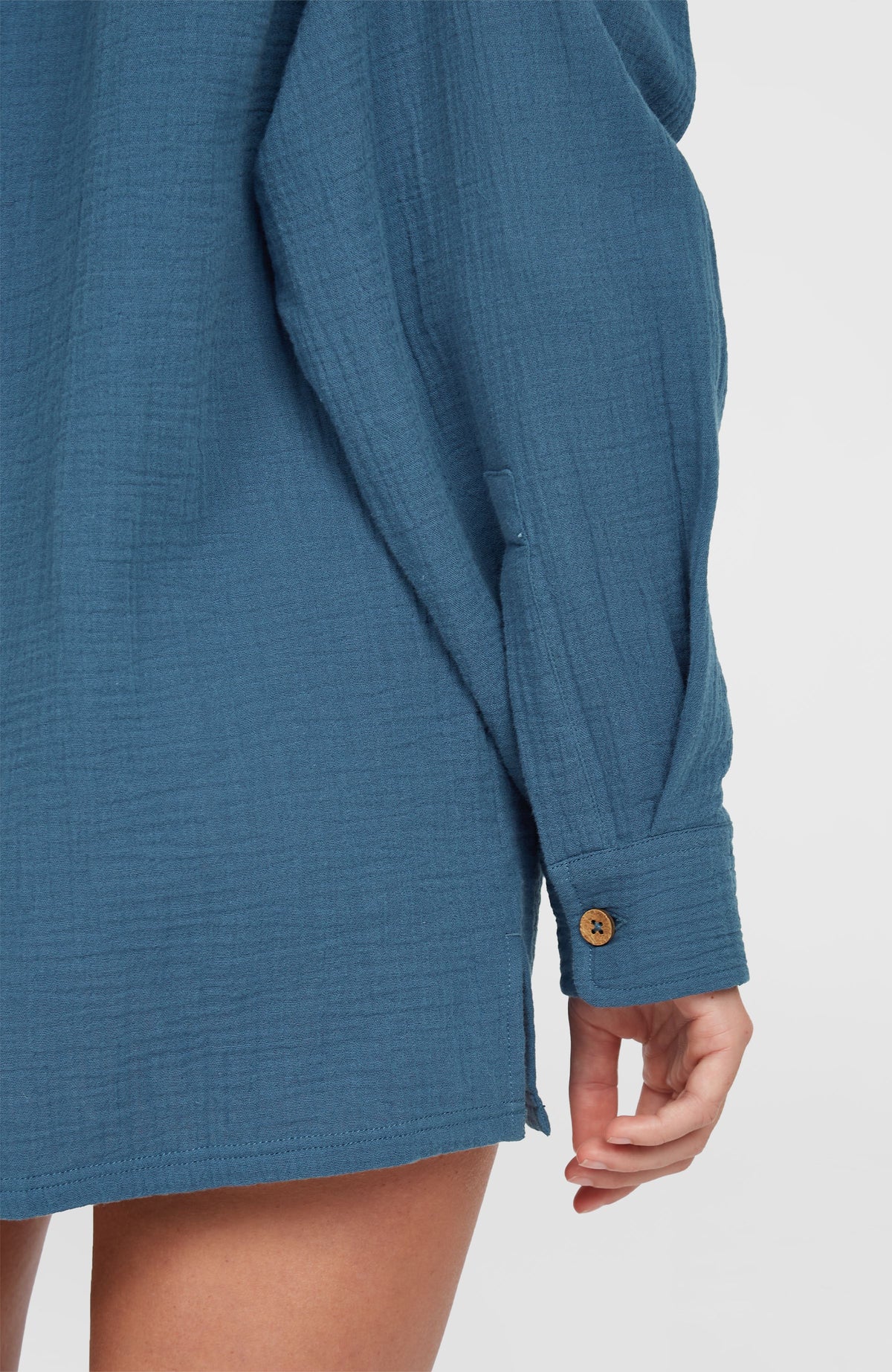Blaue Brenda Bluse für Damen, Nahaufnahme von Ärmel und geknöpfter Manschette am Model