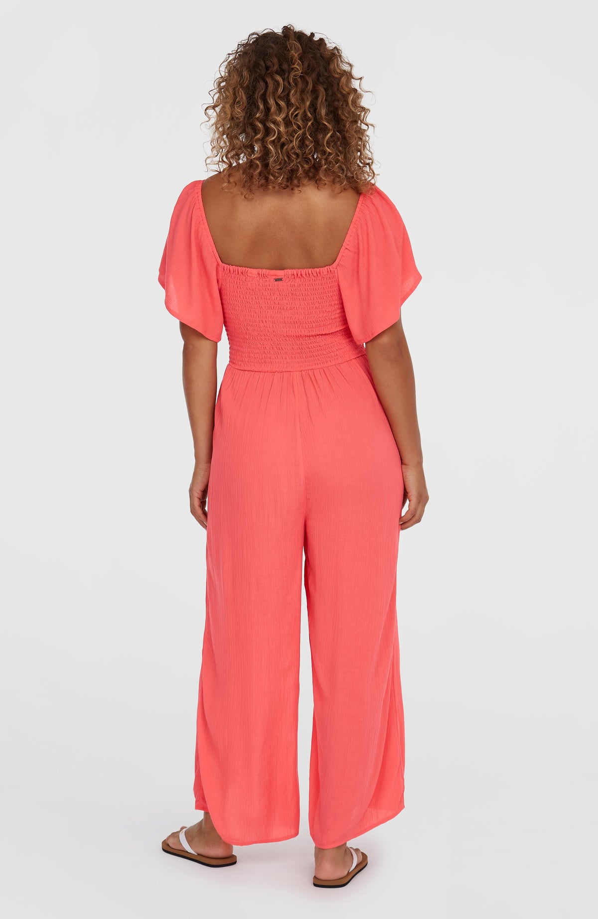 Kesia Jumpsuit für Damen, pink, getragen am Model von hinten mit weitem Hosenbein und gesmokter Rückseite
