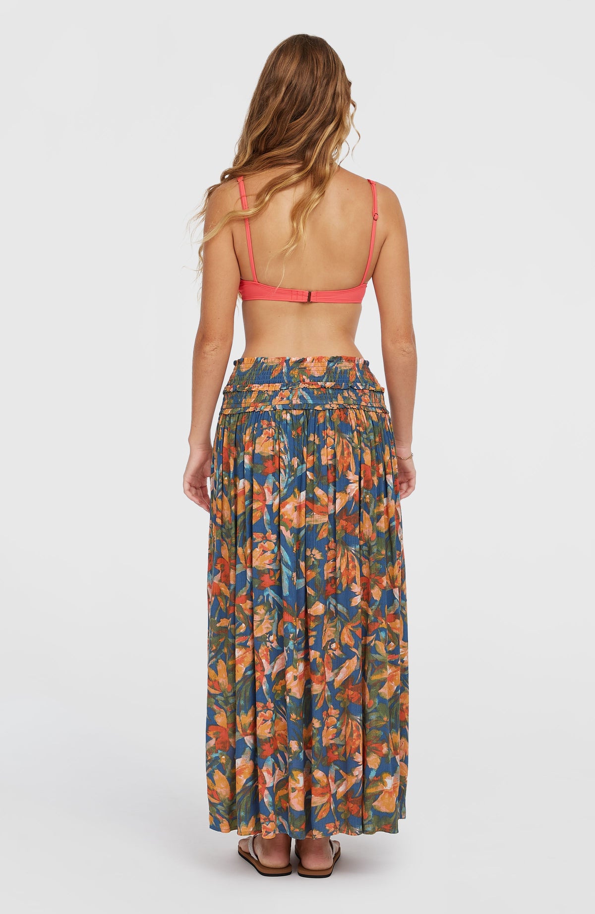 Devyn Maxirock für Damen, blau mit Blumenmuster in Orange und Gelb, Rückansicht am Model mit gesmoktem Bund