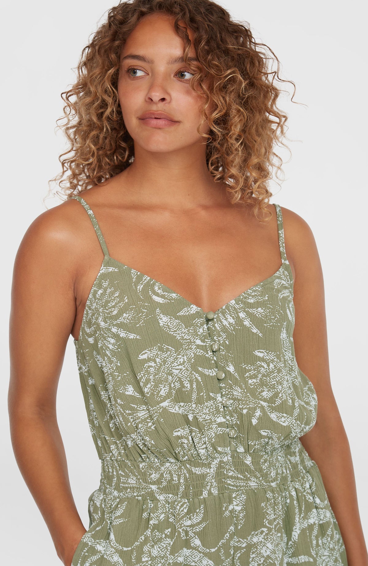 Romper mit Knöpfen für Damen, grün mit Dschungelmuster in Weiß, Nahaufnahme von Ausschnitt und Knopfleiste