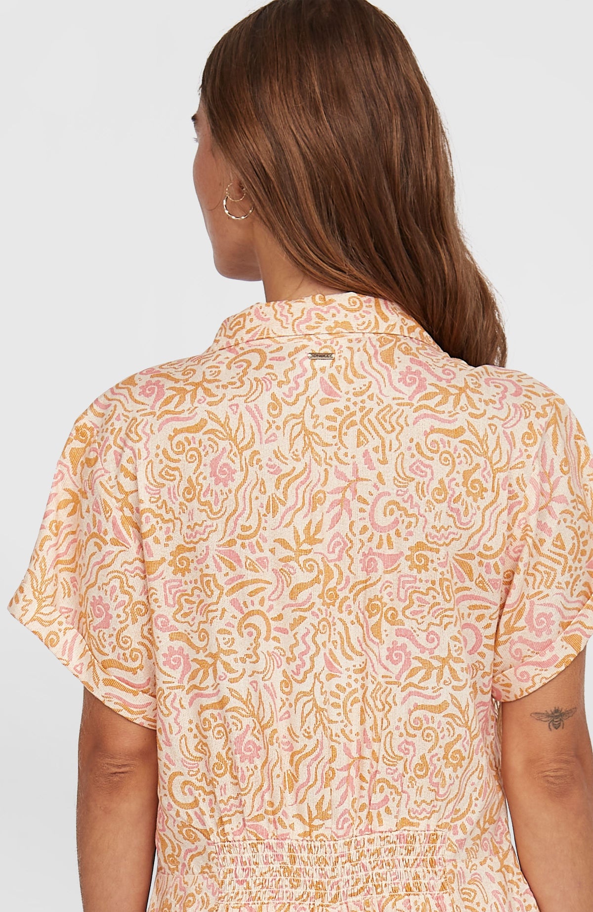 Women of the Wave Romper Jumpsuit, weiß mit Wellenmuster in Gelb und Rosa, Detailansicht der Rückenpartie am Model