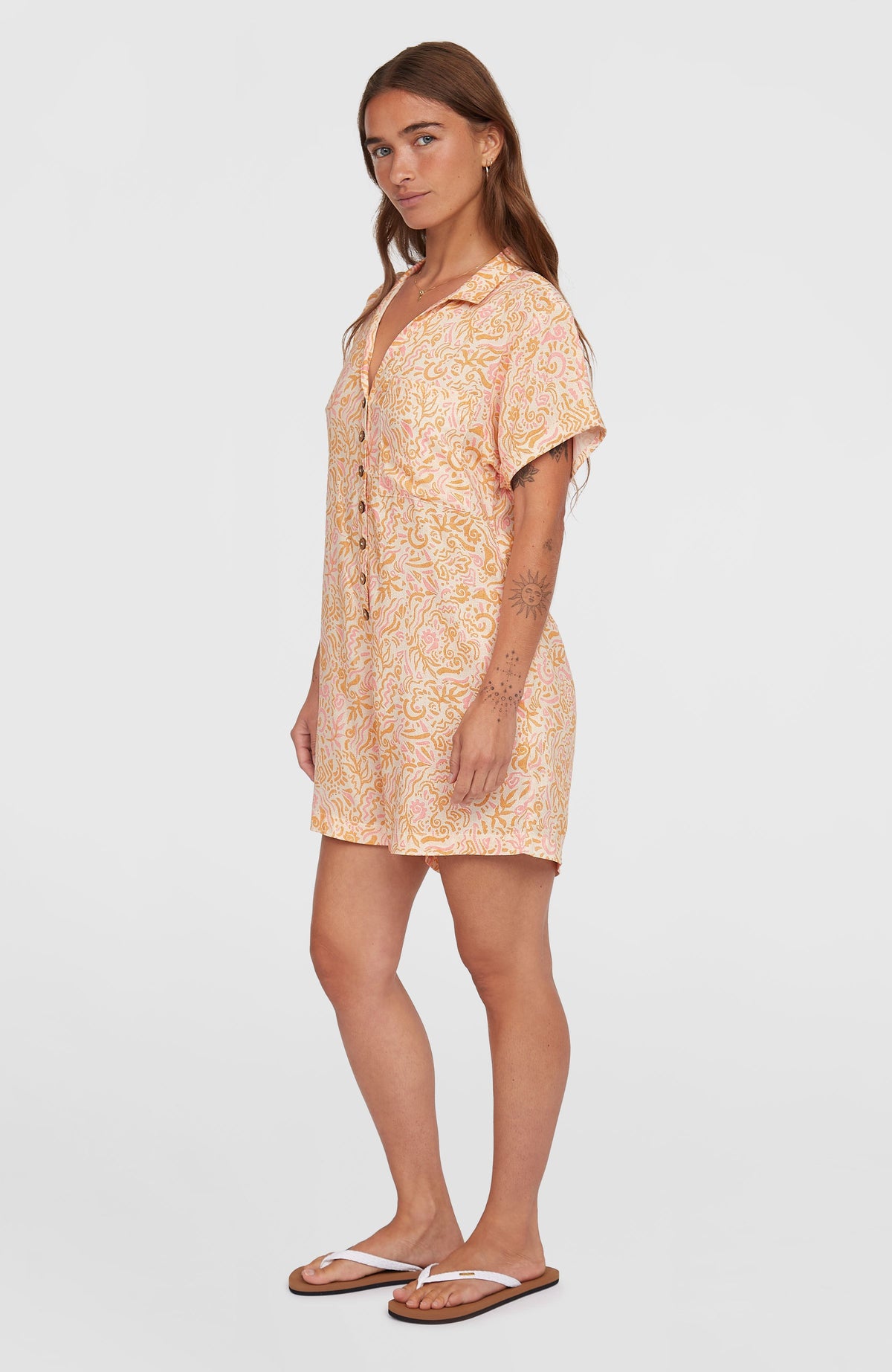 Women of the Wave Romper Jumpsuit für Damen, weiß mit Wellenmuster in Gelb und Rosa, getragen am Model von der Seite