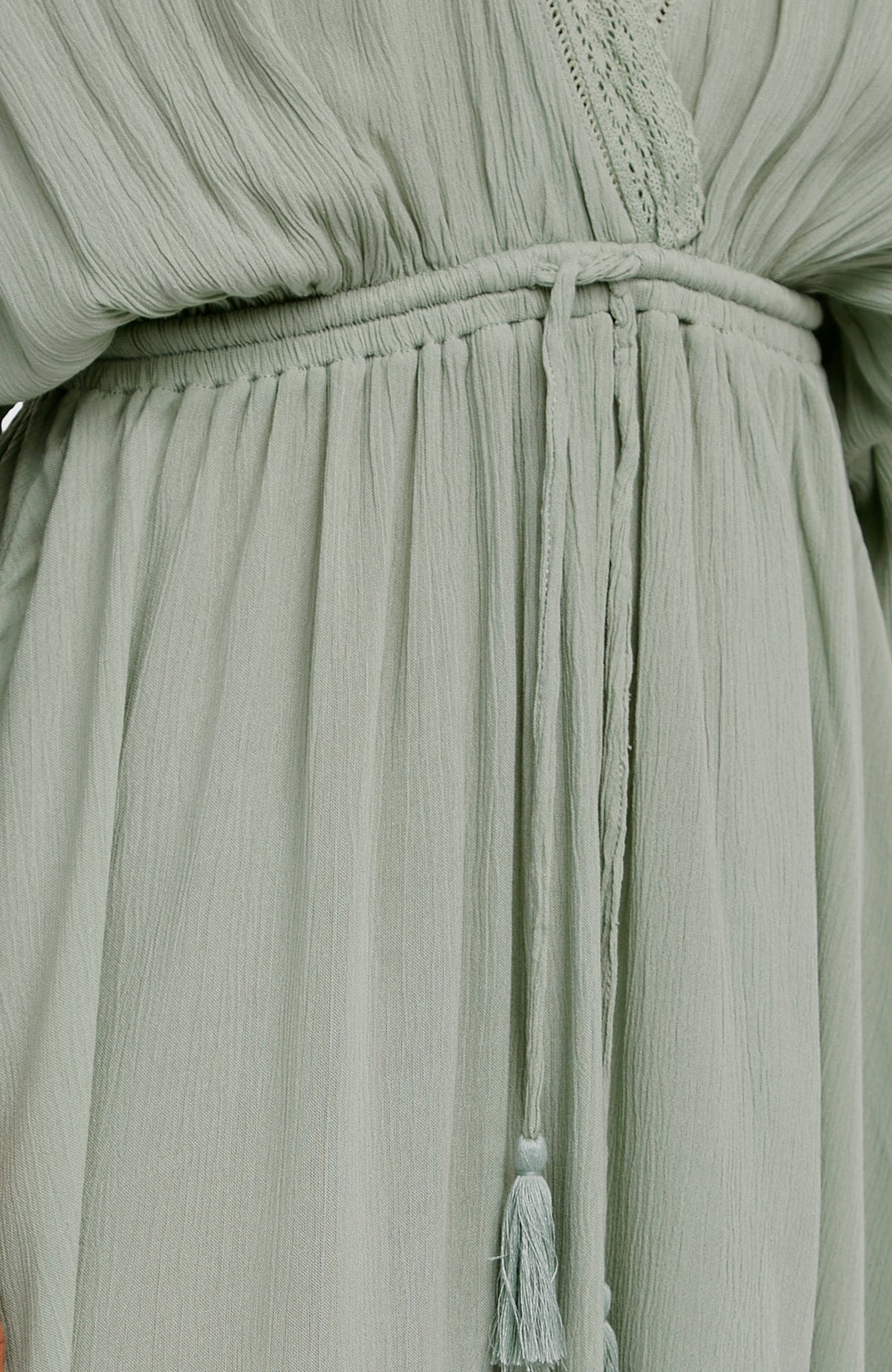 Nahaufnahme von Taillenbund und Quasten am grünen Essentials Tokeena Cover Up Kleid