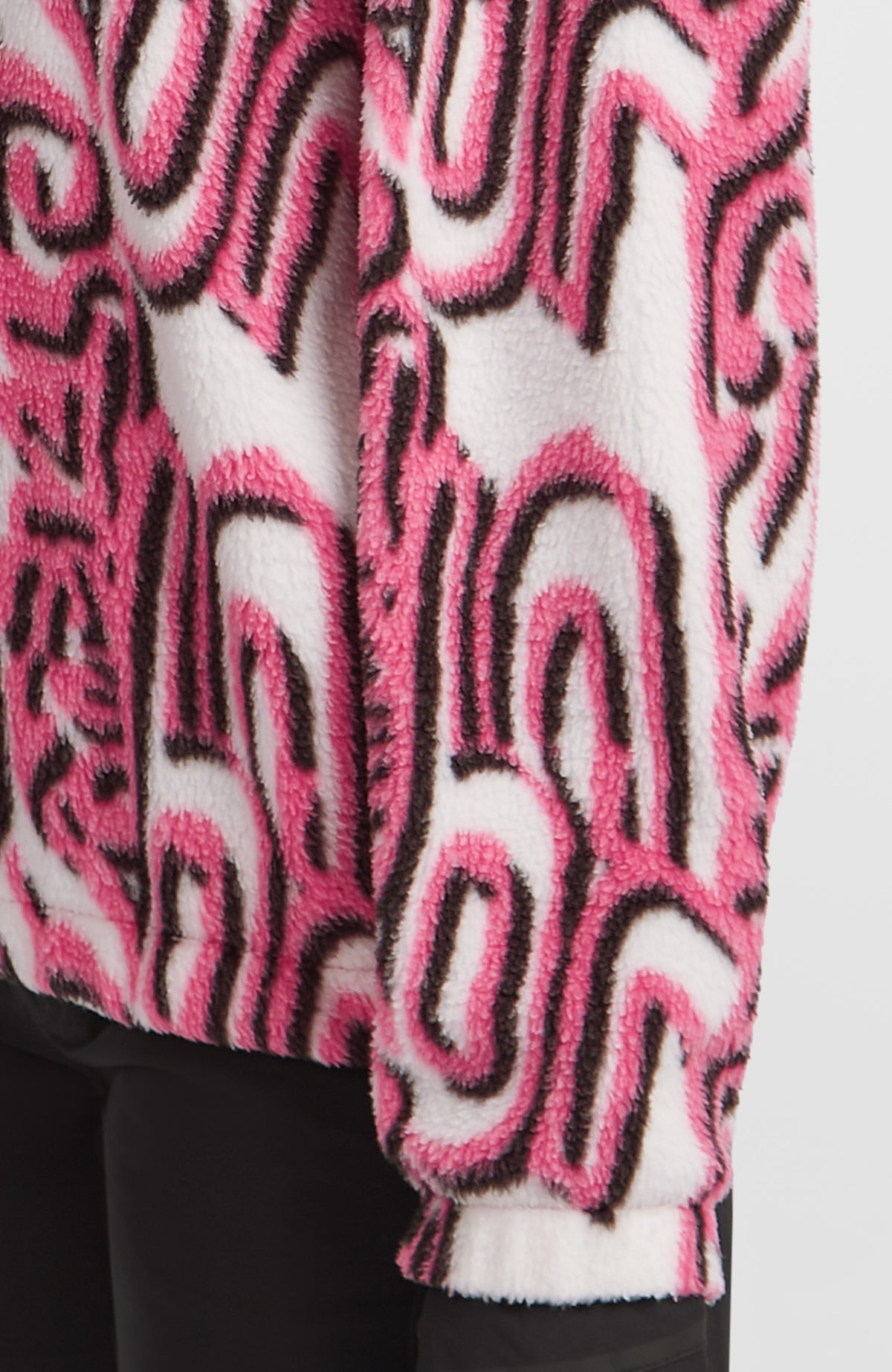 Nahaufnahme von Ärmel und Saum des weißen FWC'Play Hyperfleece Pullover mit Grafikmuster in Pink und Schwarz
