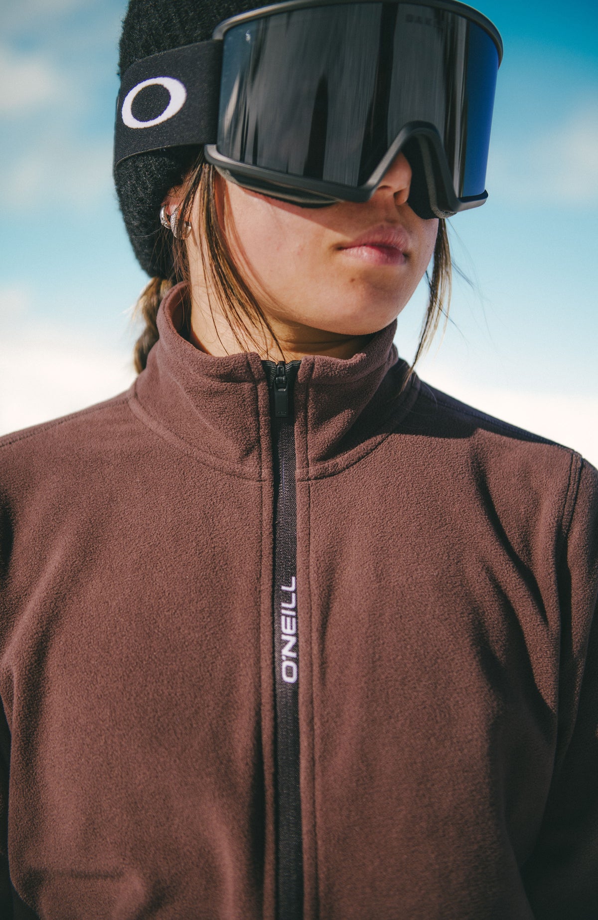 Nahaufnahme der braunen FWC'Cruz Jack's Fleecejacke für Damen, Reißverschluss mit Logo-Schriftzug