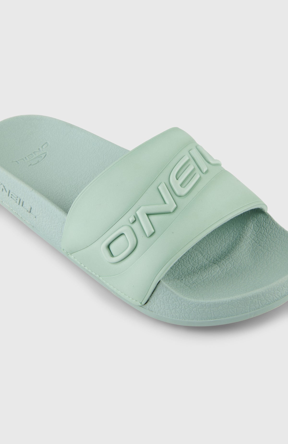 Nahaufnahme der grünen Embossed Slides für Damen, breiter Riemen mit erhabenem Schriftzug