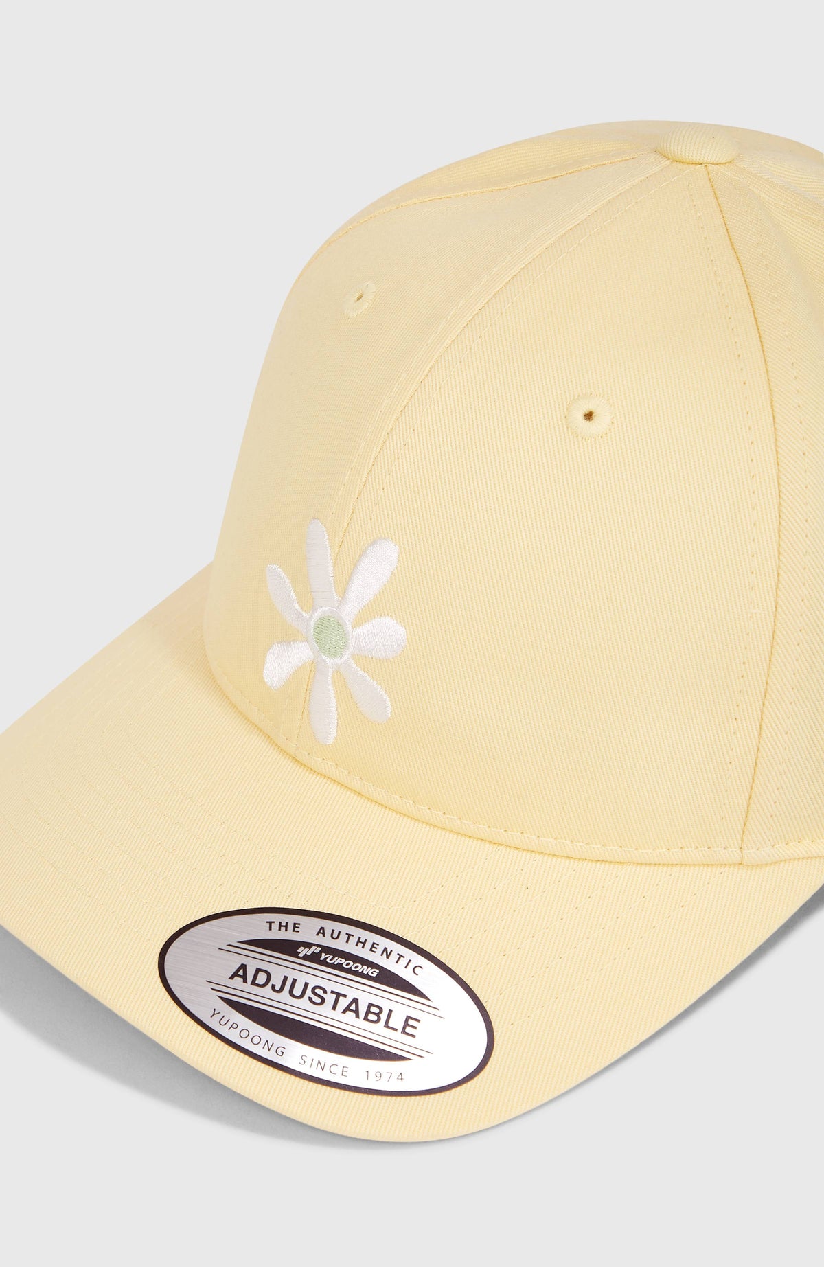 Nahaufnahme der gelben Beach Vintage Cap mit Blumen-Stickerei in Weiß auf der Vorderseite