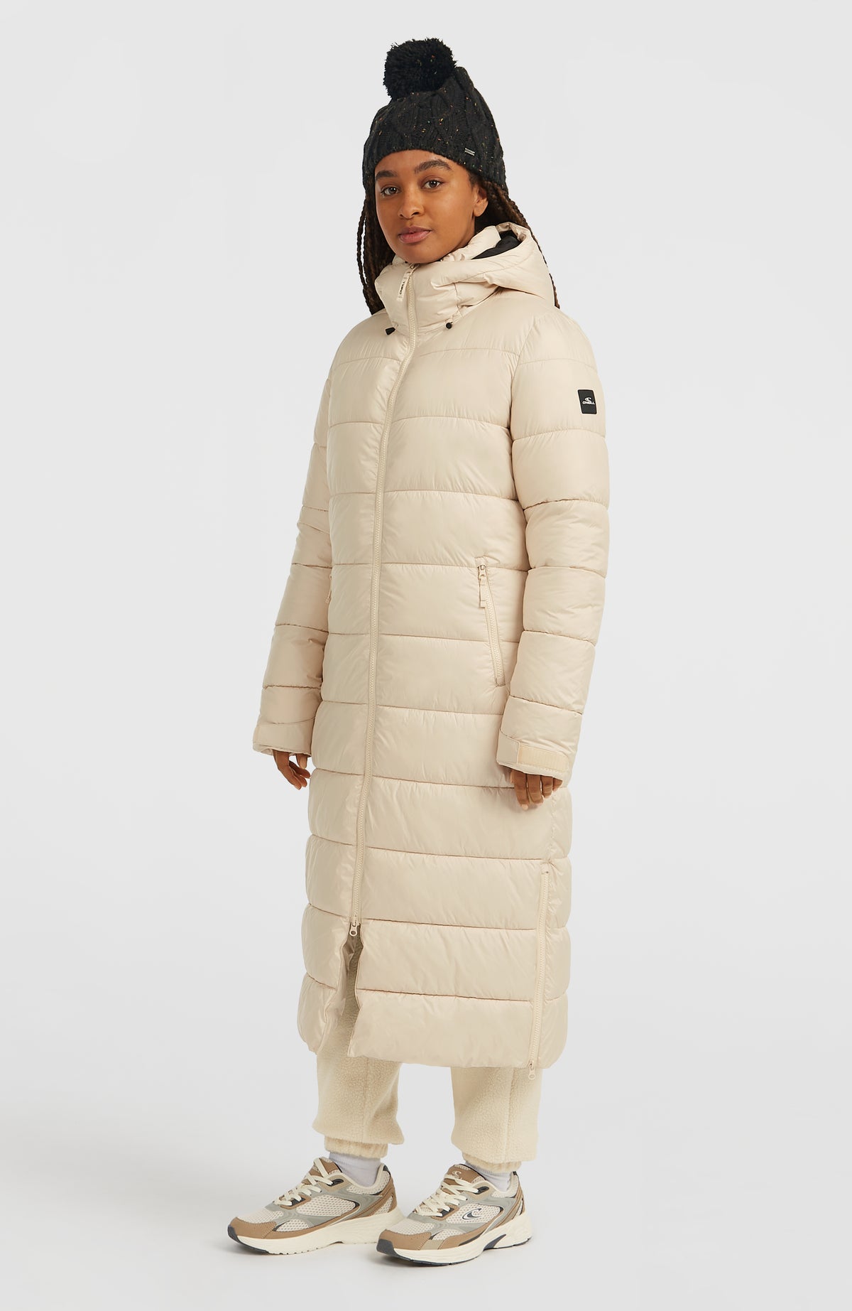 Lange Must-Have Steppjacke für Damen, beige, getragen am Model, Ansicht von schräg vorne