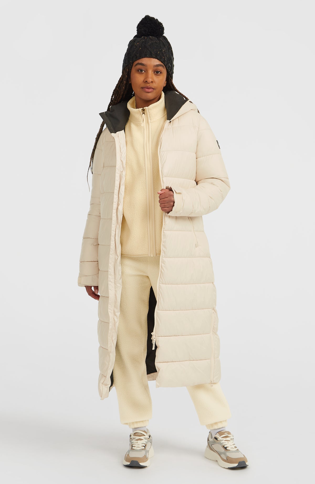 Lange Must-Have Steppjacke für Damen in Beige, getragen am Model, Vorderansicht mit geöffnetem Reißverschluss