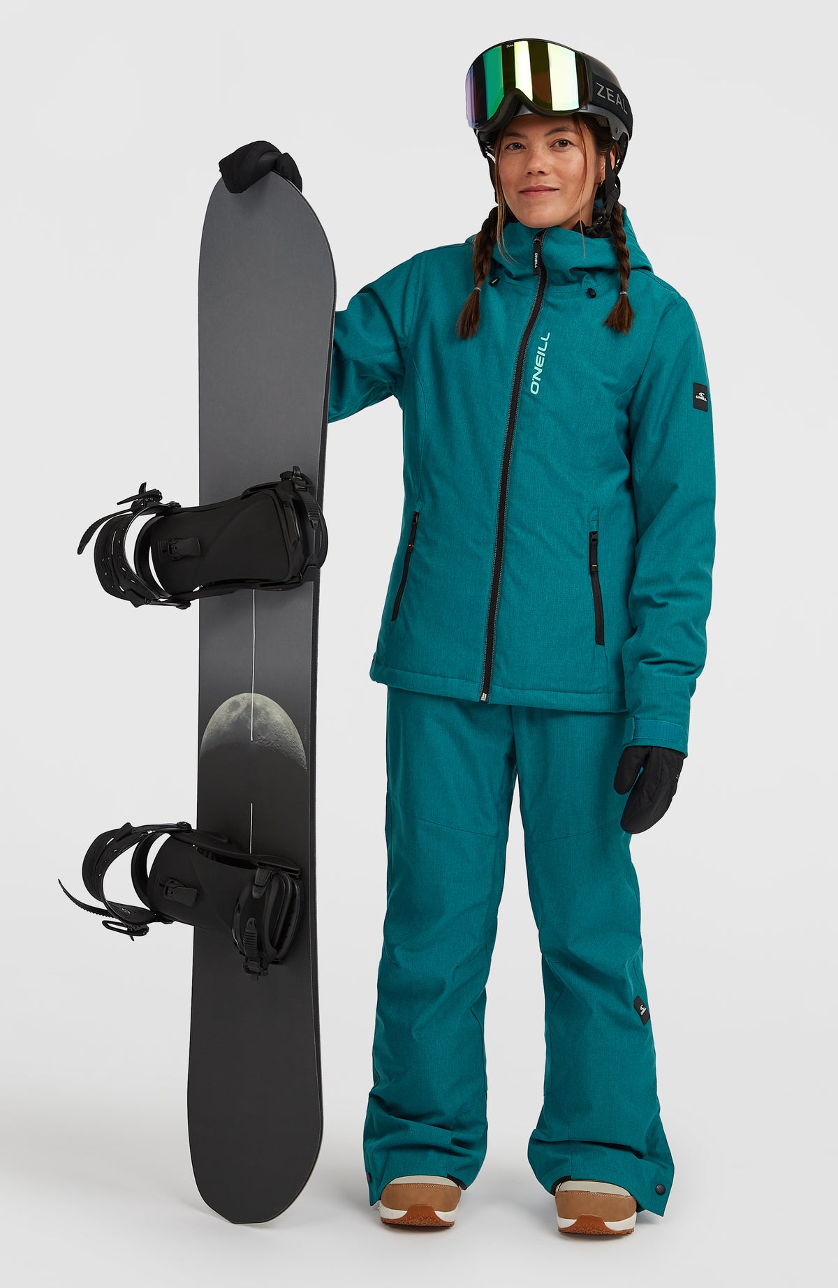 Blaue FWC'Cruz Melange Skijacke für Damen, getragen am Model mit passender Skihose und Snowboard