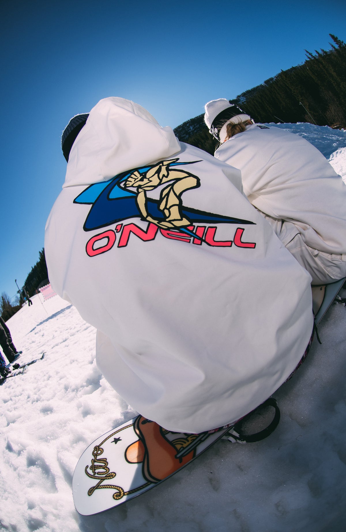 FWC'Play Softshell-Hoodie für Damen, weiß, im Schnee getragen am Model, Rückansicht mit großem Rückenprint