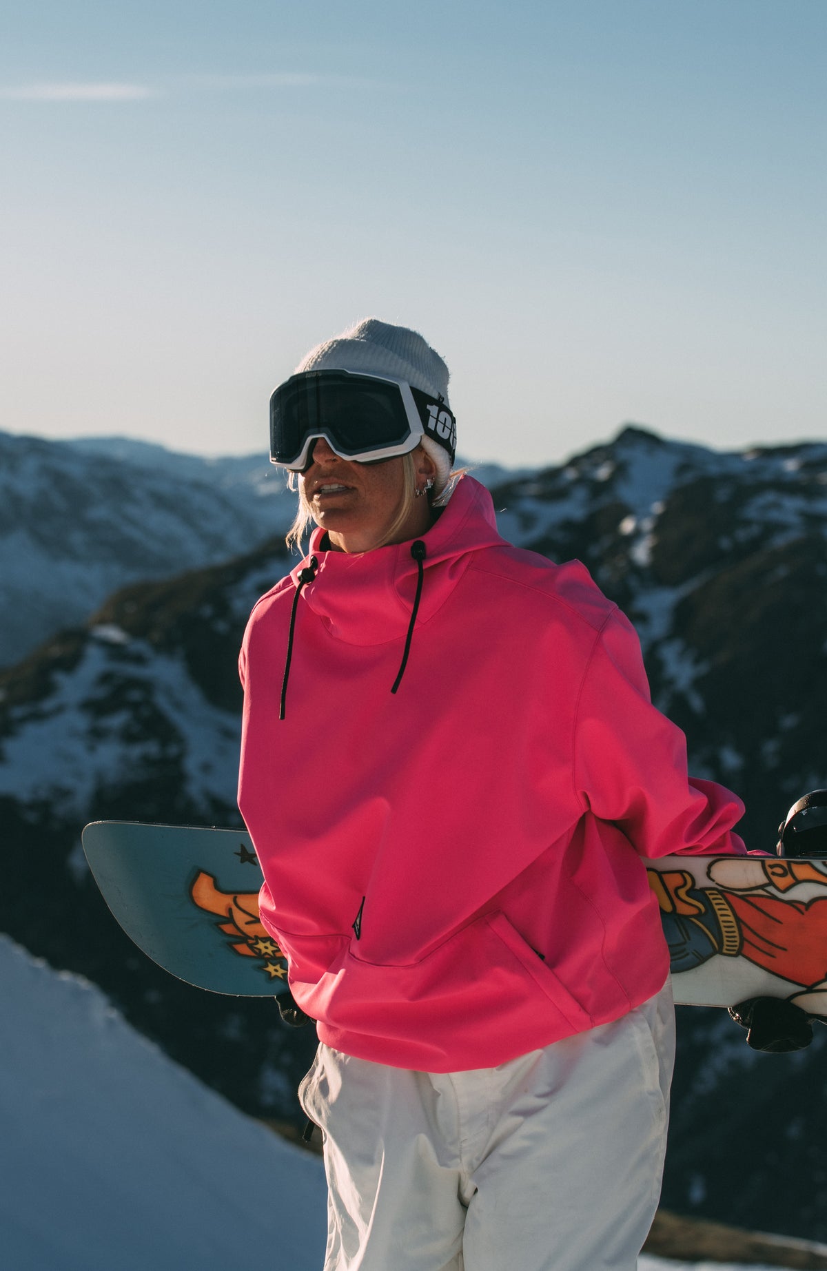 FWC'Play Softshell-Hoodie für Damen, pink, im Schnee, Frontansicht mit Snowboard