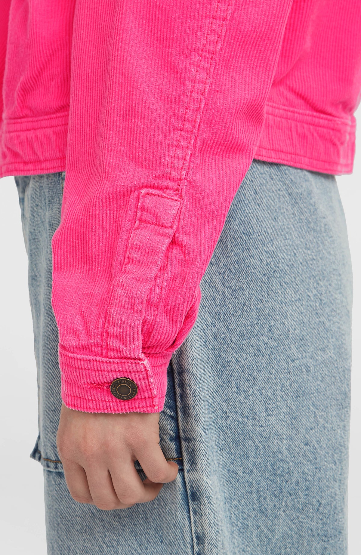 Nahaufnahme des Ärmelabschlusses mit Metallknopf an der pinken O'Riginals Cordjacke