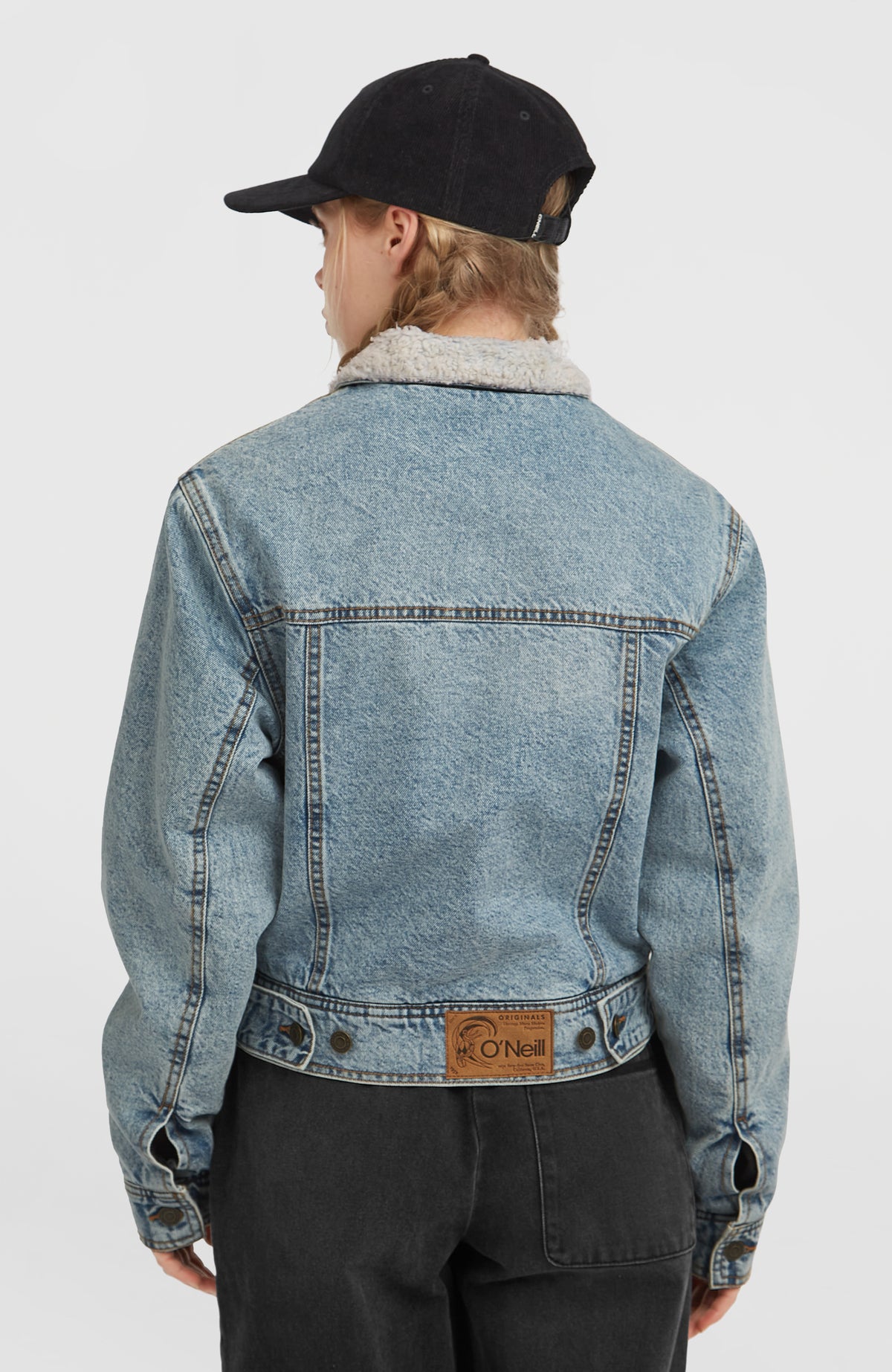 O'Riginals Jeansjacke für Damen, blau, Rückenansicht am Model mit Ziernähten und Logo-Patch am Saum