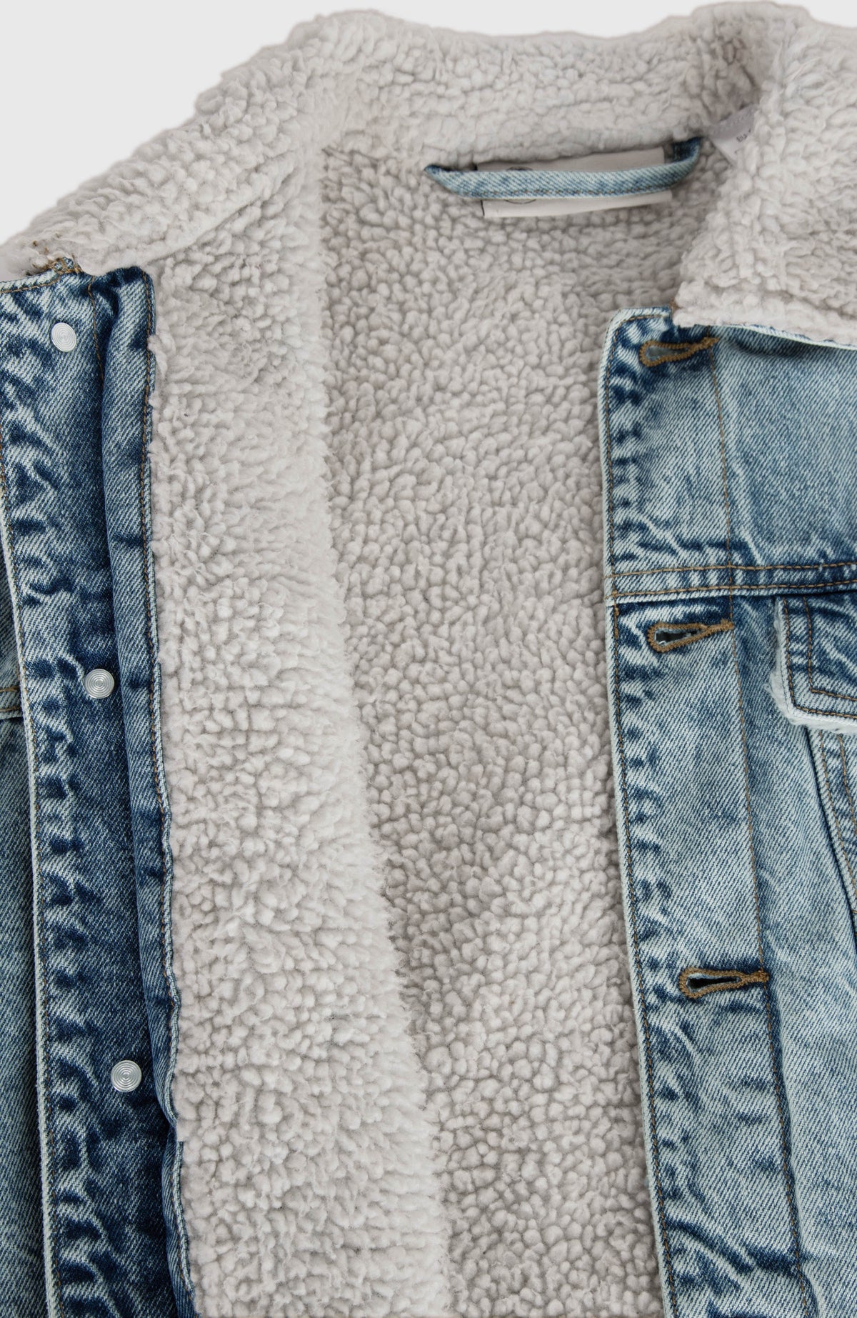 O'Riginals Jeansjacke, blau, Nahaufnahme des hellen Innenfutters und der geöffneten Knopfleiste