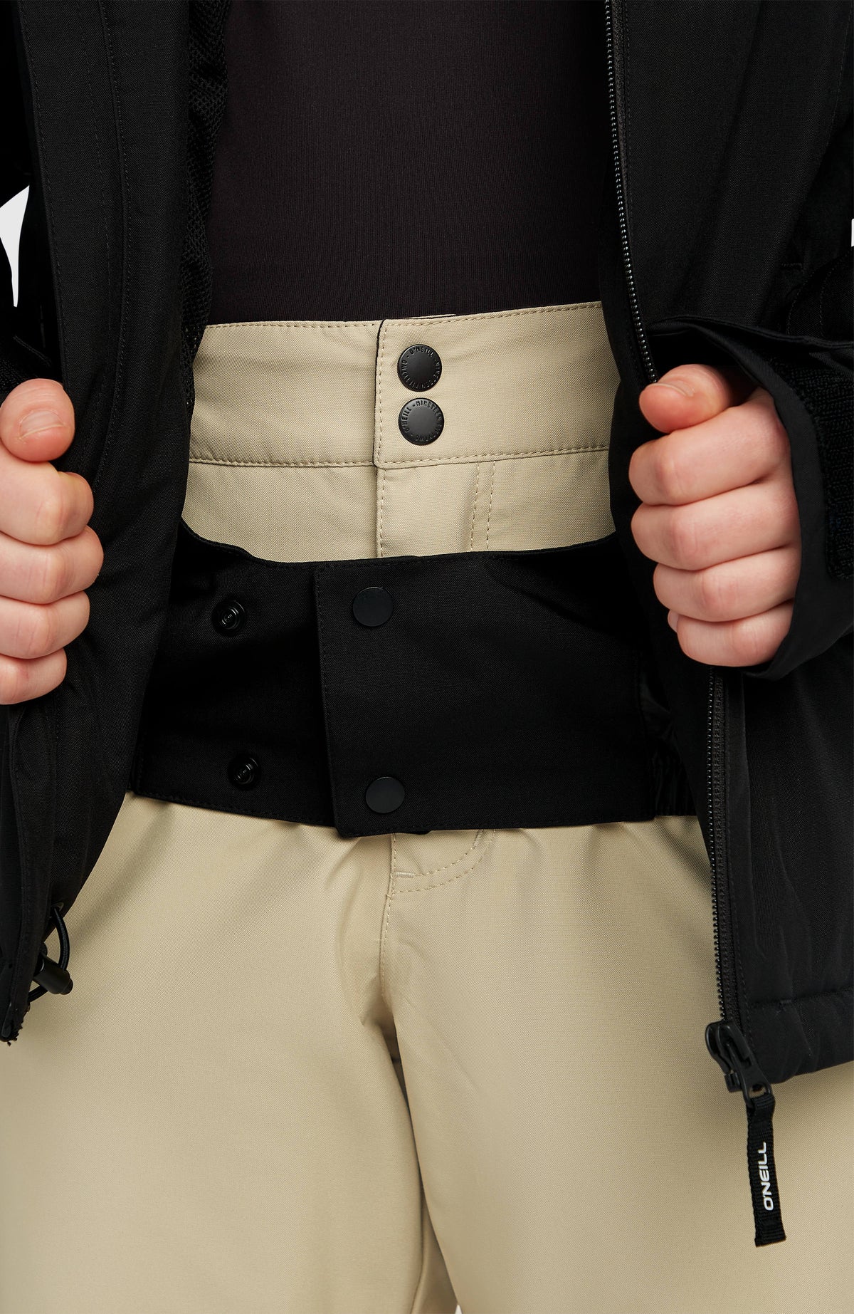 FWC'Cruz Skijacke, schwarz, Nahaufnahme am Model mit geschlossenem Schneefang an der Hose
