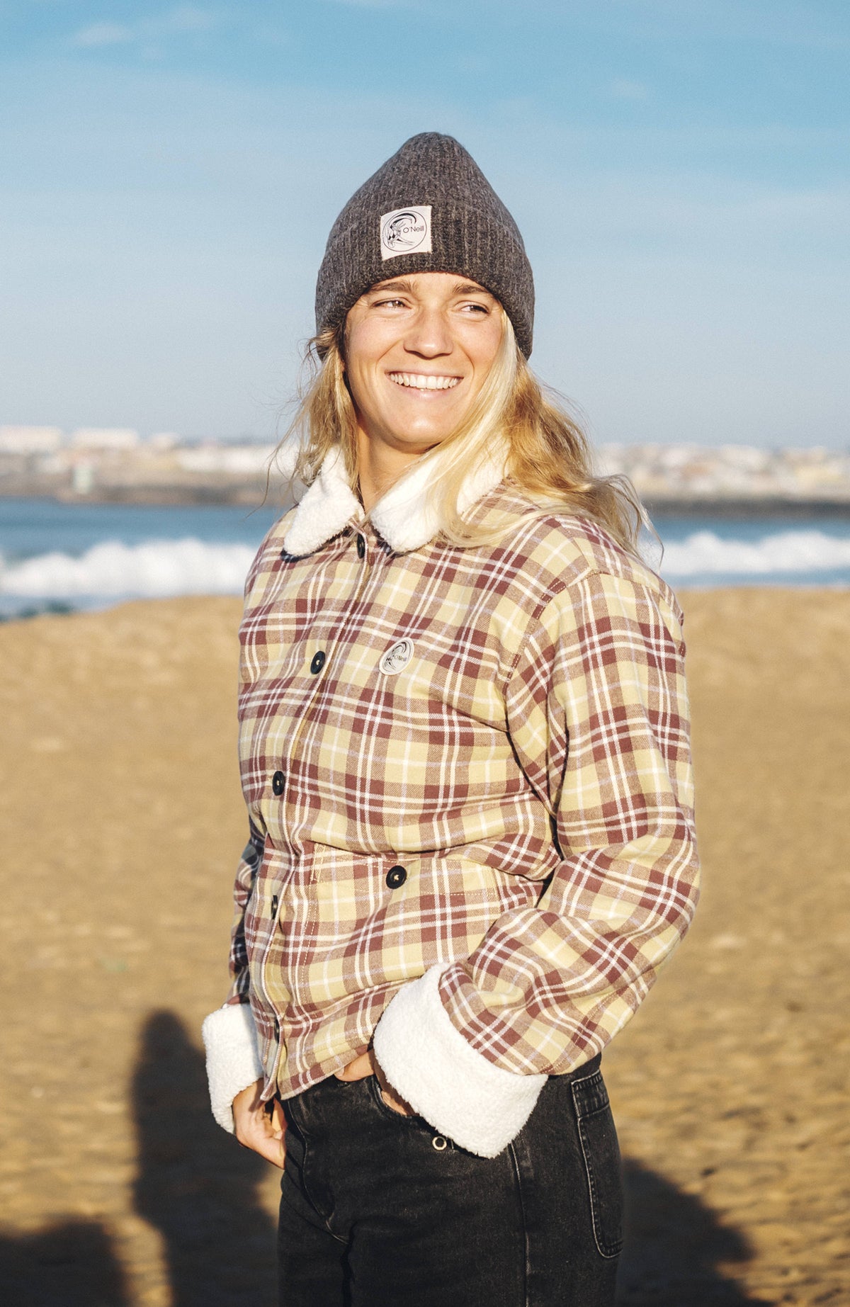 O'Neill O'Riginals Jacke mit Fleecefutter für Damen, grau mit Karomuster in Braun und Weiß, getragen am Strand