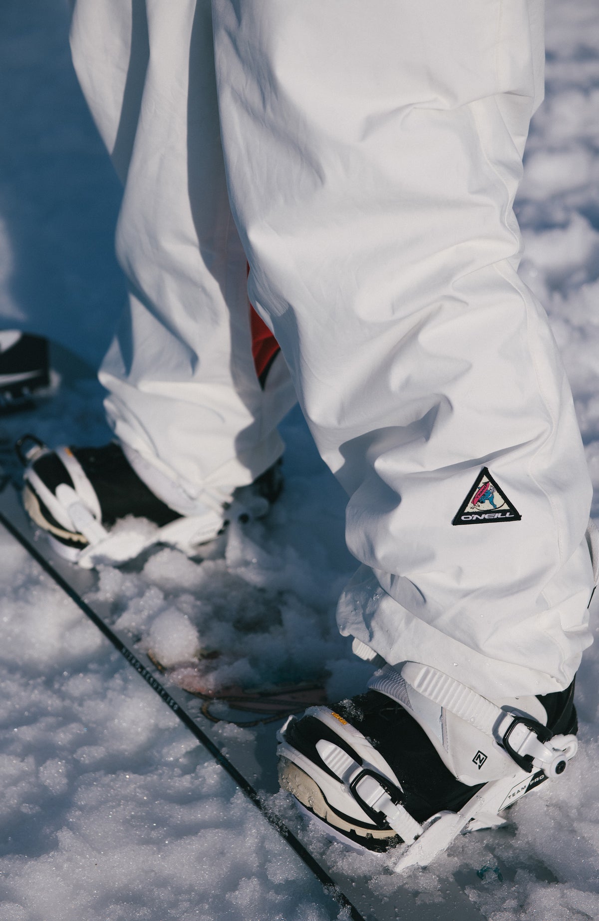 FWC'Play Ski- und Snowboardhose für Damen, weiß, im Schnee auf einem Snowboard