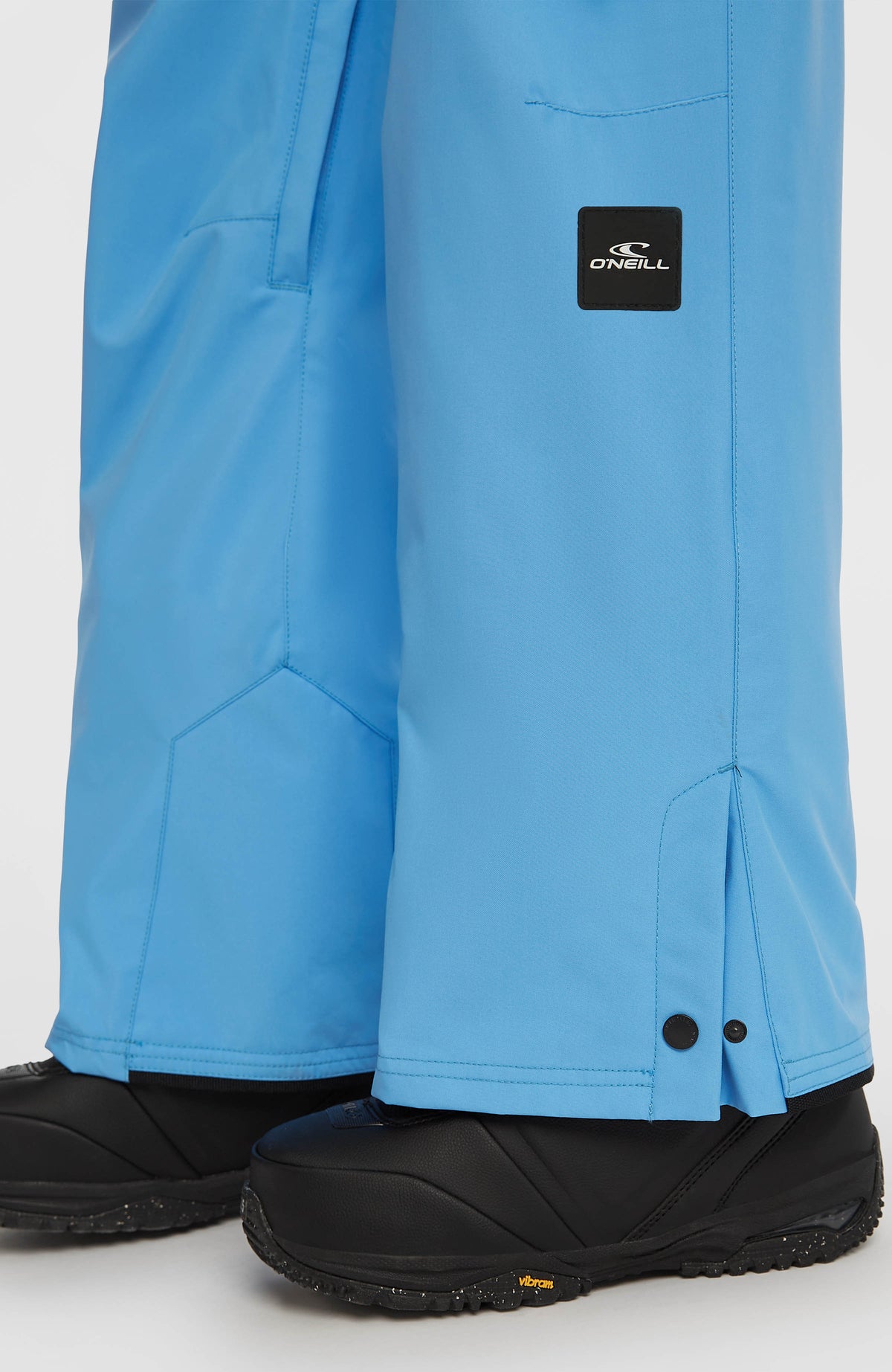 Nahaufnahme des unteren Hosenbeins mit Druckknöpfen am Saum der blauen FWC'Cruz Cargo-Skihose